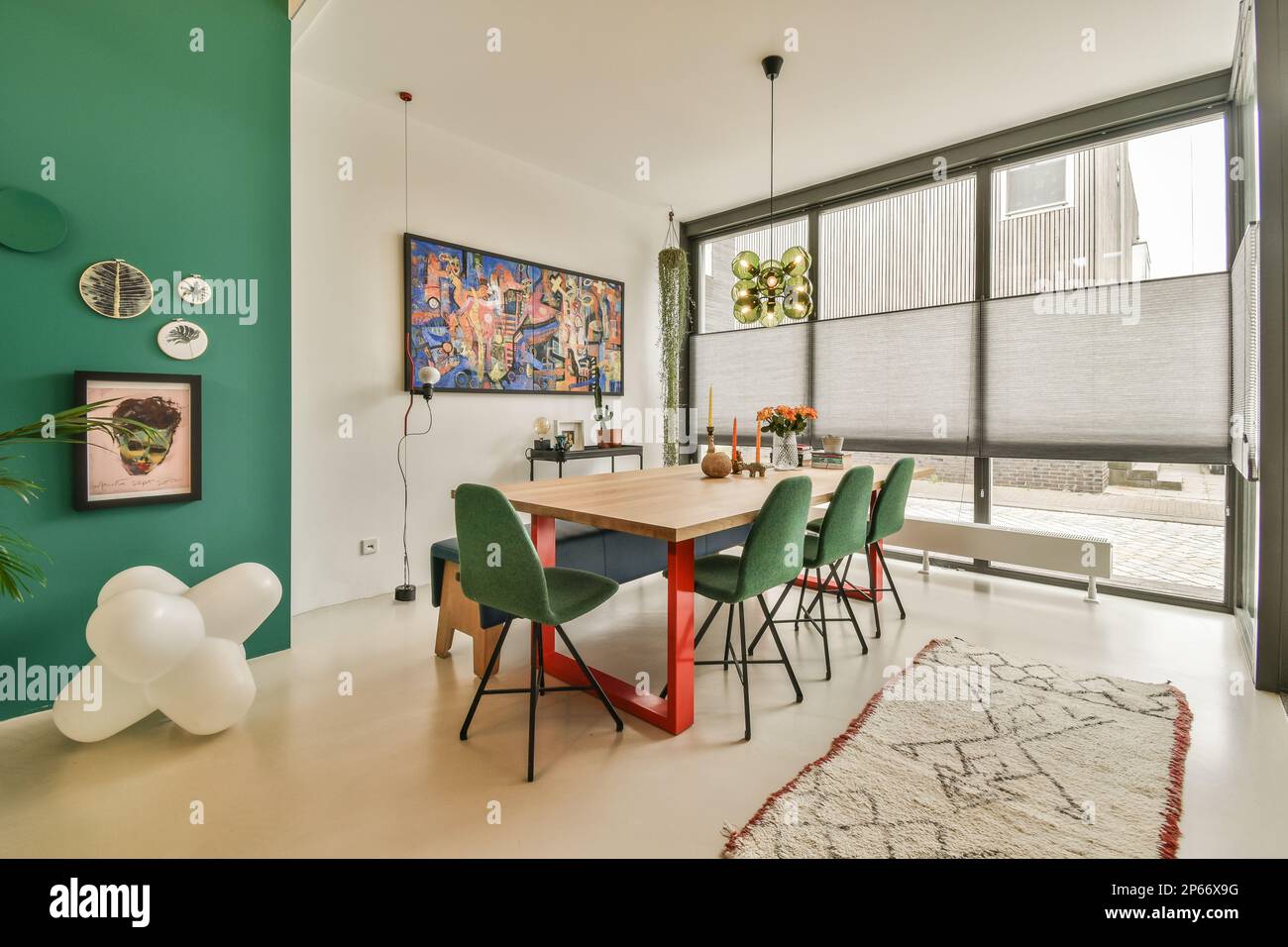 un soggiorno con pareti verdi e pavimento bianco, che include un tavolo da  pranzo in legno circondato da due sedie colorate Foto stock - Alamy