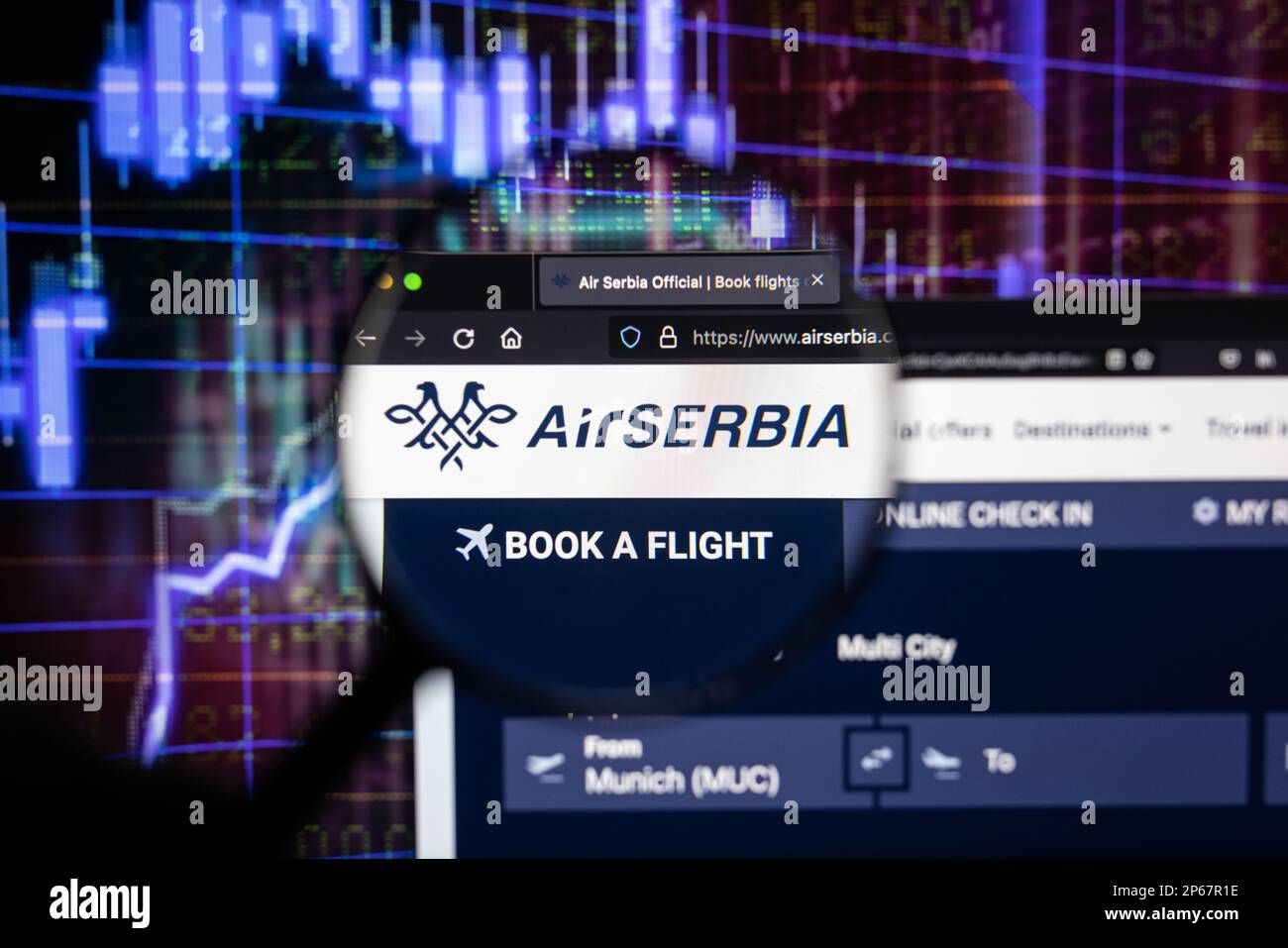 Air Serbia logo compagnia aerea su un sito web con blurry mercato azionario sviluppi in background, visto su uno schermo attraverso una lente di ingrandimento Foto Stock