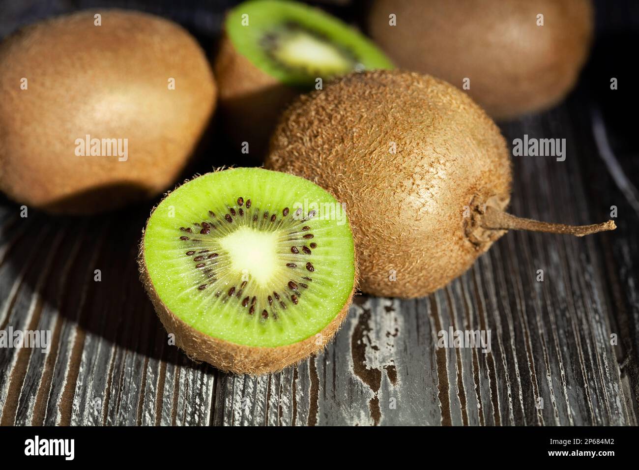 kiwi a fette su sfondo di legno Foto Stock