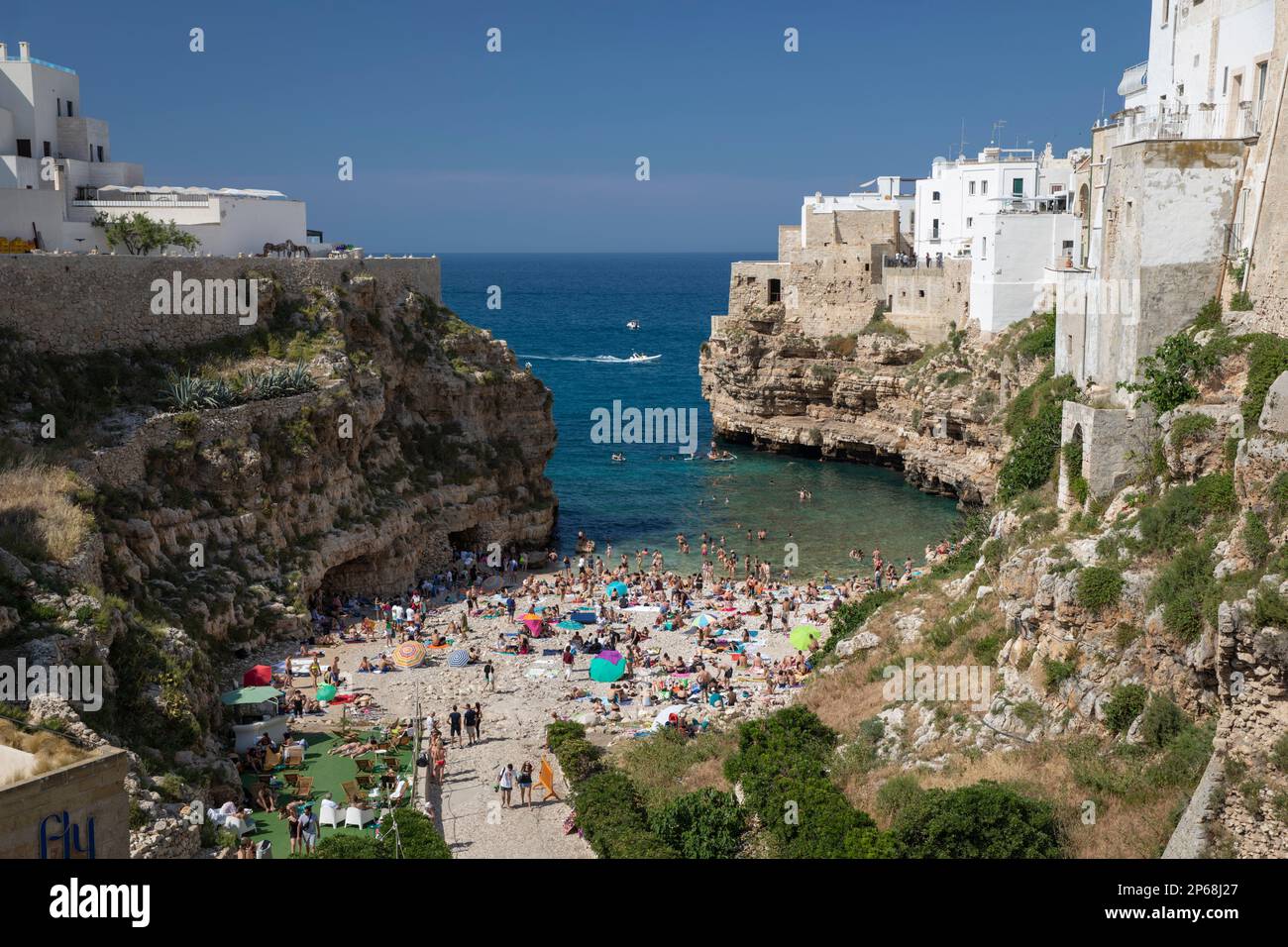 Vista della spiaggia e del centro storico su scogliere calcaree vista dal ponte Borbonico su lama Monachile, Polignano a Mare, Puglia, Italia, Europa Foto Stock
