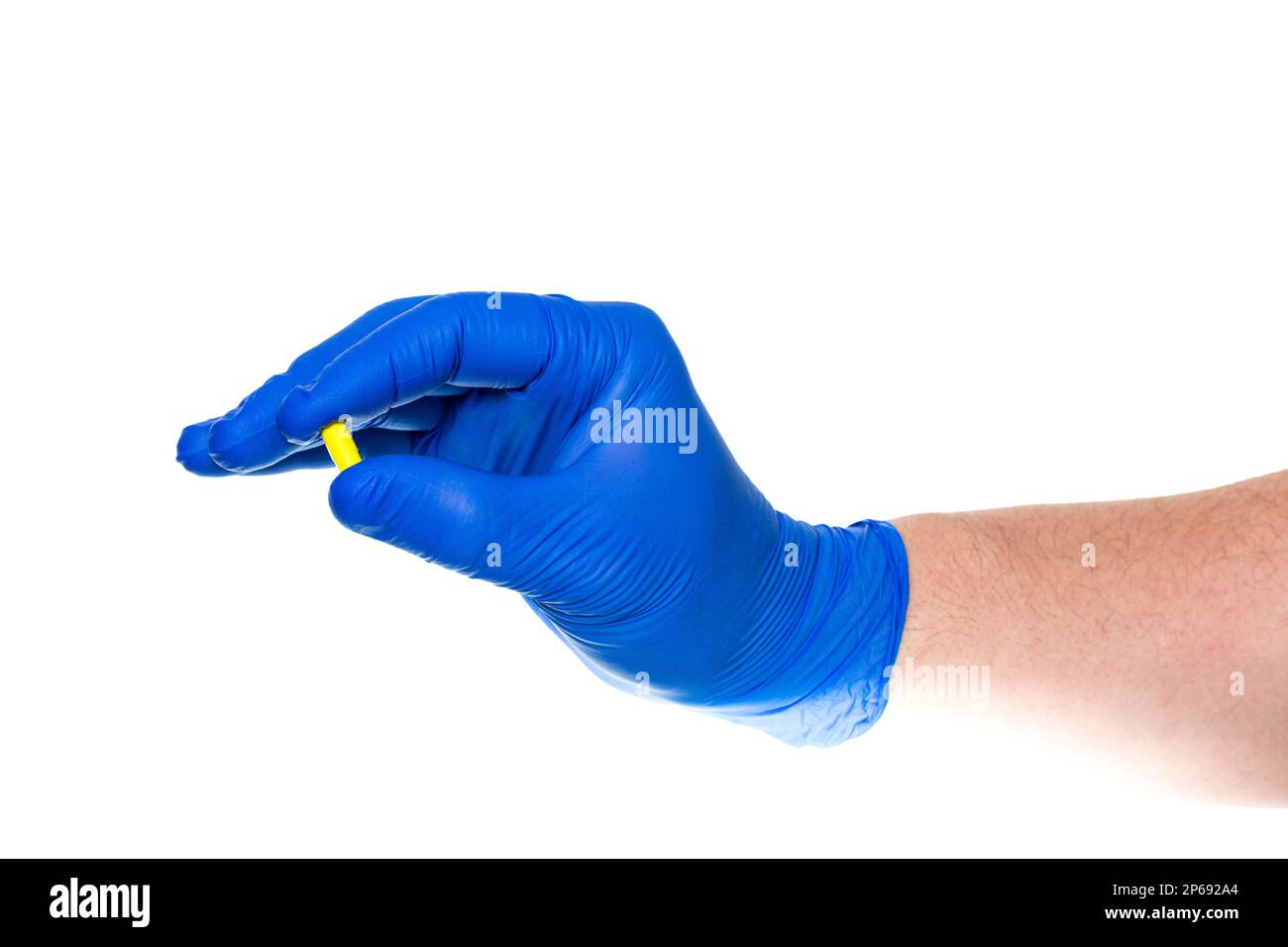 Crop mano irriconoscibile del medico in guanto di lattice blu che tiene la pillola gialla isolato su sfondo bianco Foto Stock