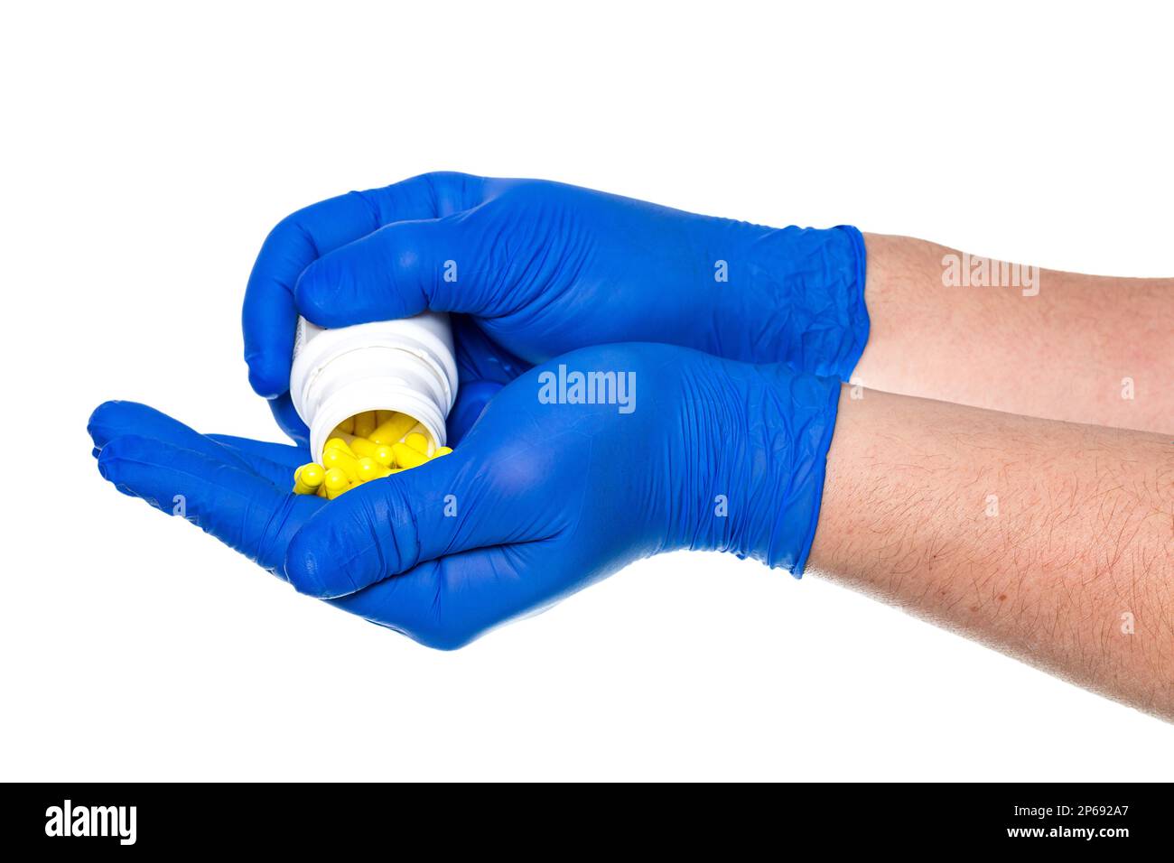 Crop mani anonime del medico in guanti di lattice dimostrando manciata di pillole isolate su sfondo bianco Foto Stock