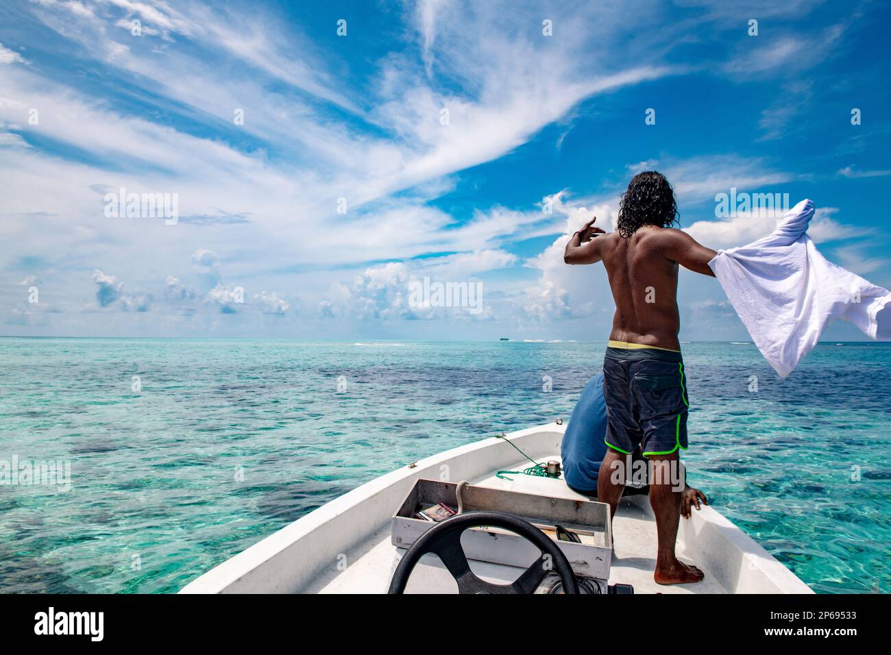 Uomo da dietro guardando la vista durante un'escursione in barca, Maldive Foto Stock