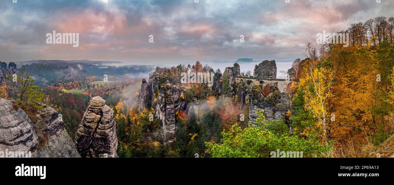 Paesaggio panoramico nel Parco Nazionale Sächsische Schweiz con formazioni rocciose e il ponte Basteibrücke in autunno all'alba. Foto Stock