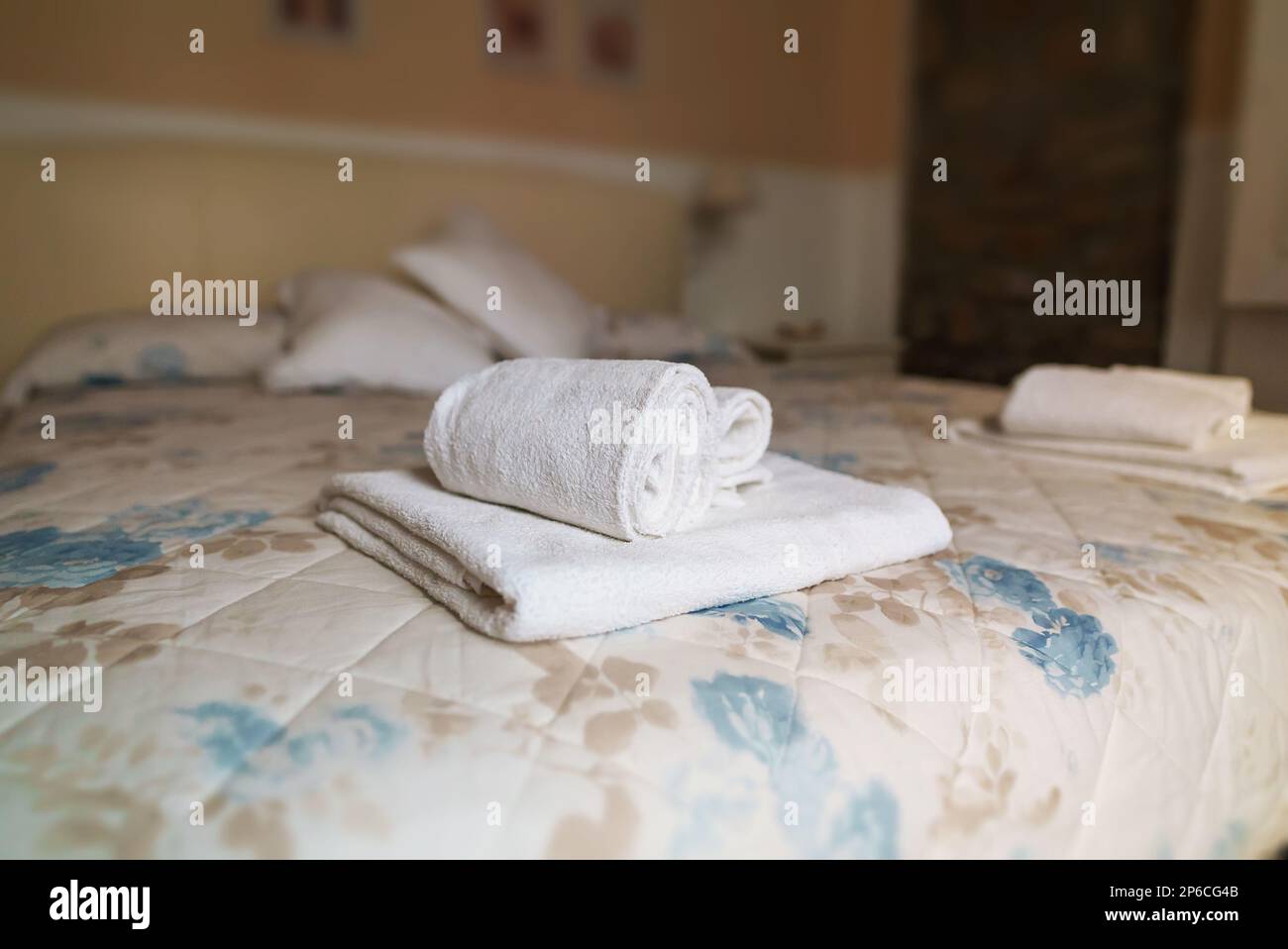 Asciugamani bianchi in camera da letto. Concetto di pulizia delle camere. Foto Stock