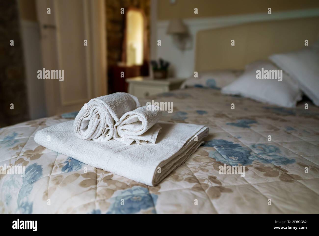 Asciugamani bianchi in camera da letto. Concetto di pulizia delle camere. Foto Stock