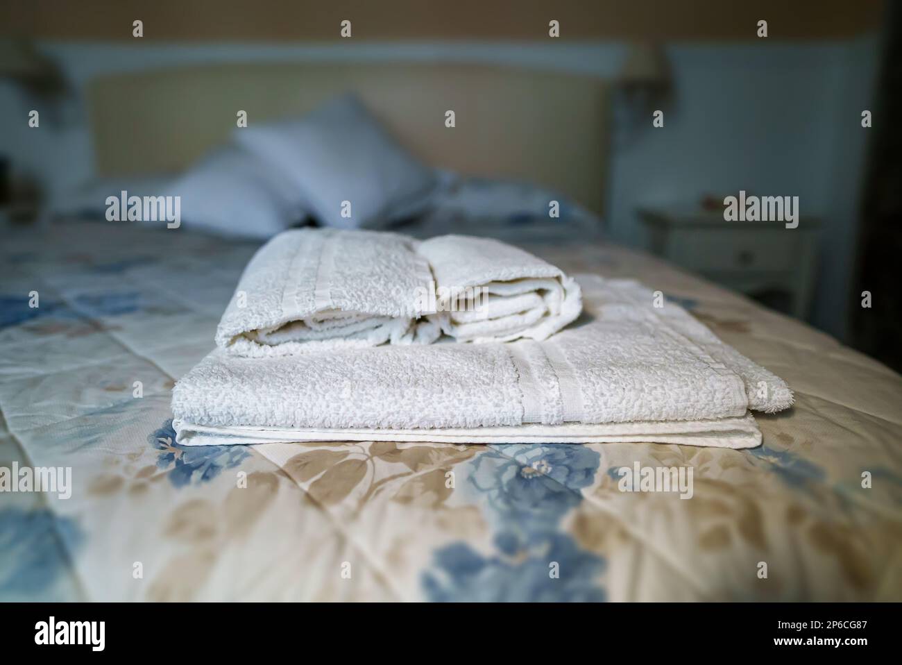 Asciugamani bianchi in camera da letto. Concetto di pulizia delle camere. Foto Stock