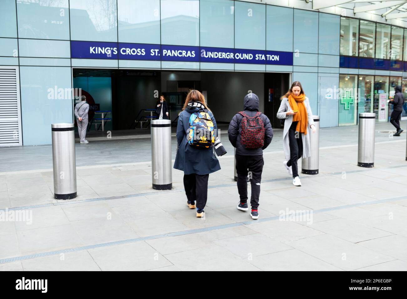 Vista posteriore madre adolescente figlio persone che camminano in strada fuori dall'entrata Kings Cross St Pancras stazione della metropolitana Londra UK KATHY DEWITT Foto Stock