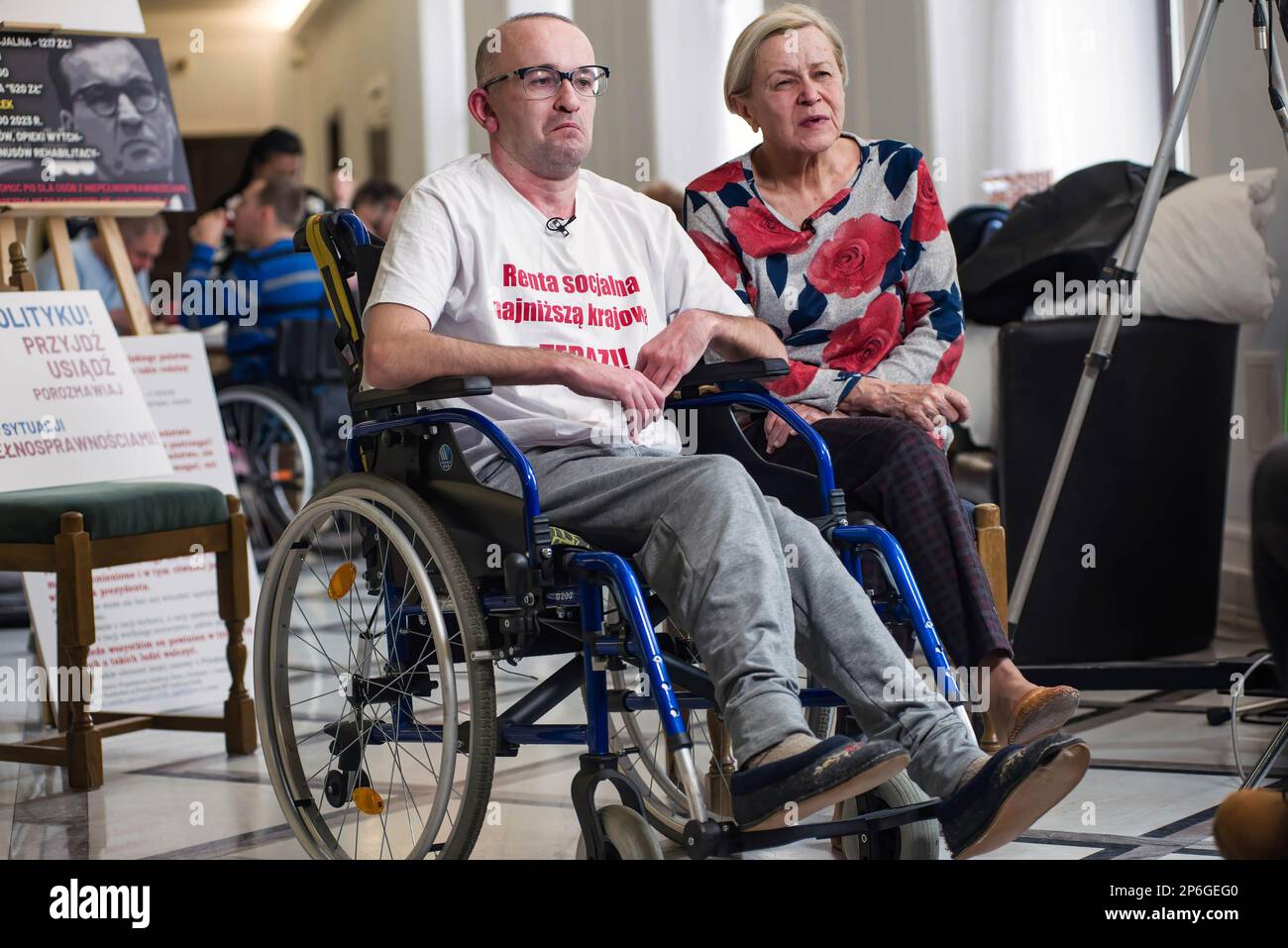 Un uomo diversamente abile si vede con sua madre durante la protesta al corridoio parlamentare. Un gruppo di persone con disabilità, insieme ai loro genitori e alle persone che si prendono cura si sono riuniti ieri nel Sejm (casa bassa del Parlamento), chiedendo che la pensione sociale sia equalizzata con il minimo nazionale. Tra i manifestanti nel Sejm è anche un deputato - Iwona Hartwich con il suo figlio disabili, Jakub. Il deputato della PO (piattaforma Civica) ha informato durante una conferenza stampa che le persone con disabilità stanno presentando un progetto di legge sulla pensione sociale, dopo il quale sono già state cofirmate quasi 200.000 firme Foto Stock