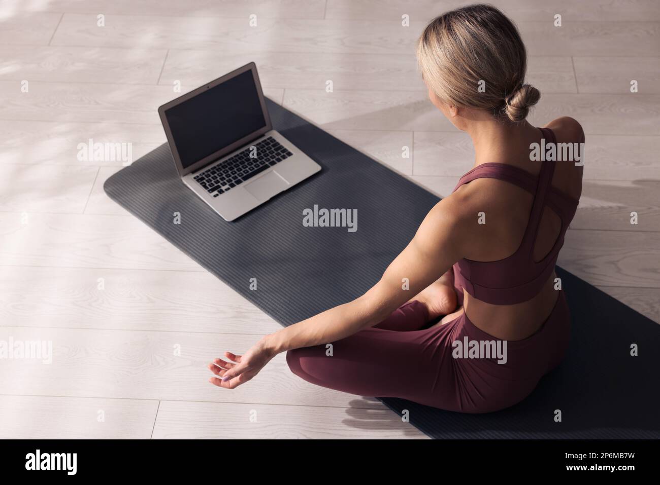 Donna che guarda classe di yoga online a casa Foto Stock