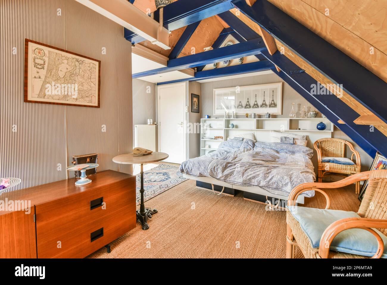 Amsterdam, Paesi Bassi - 10 Aprile, 2021: Una camera da letto con un letto, scrivania e sedia sotto le scale in uno spazio mansardato che è stato utilizzato per molti anni Foto Stock