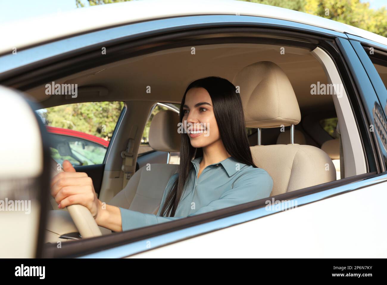 Bellissimo giovane autista seduto in auto moderna Foto Stock