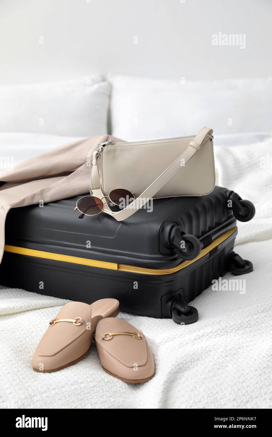 Valigia confezionata per viaggi, scarpe, giacca e accessori alla moda sul  letto in camera Foto stock - Alamy