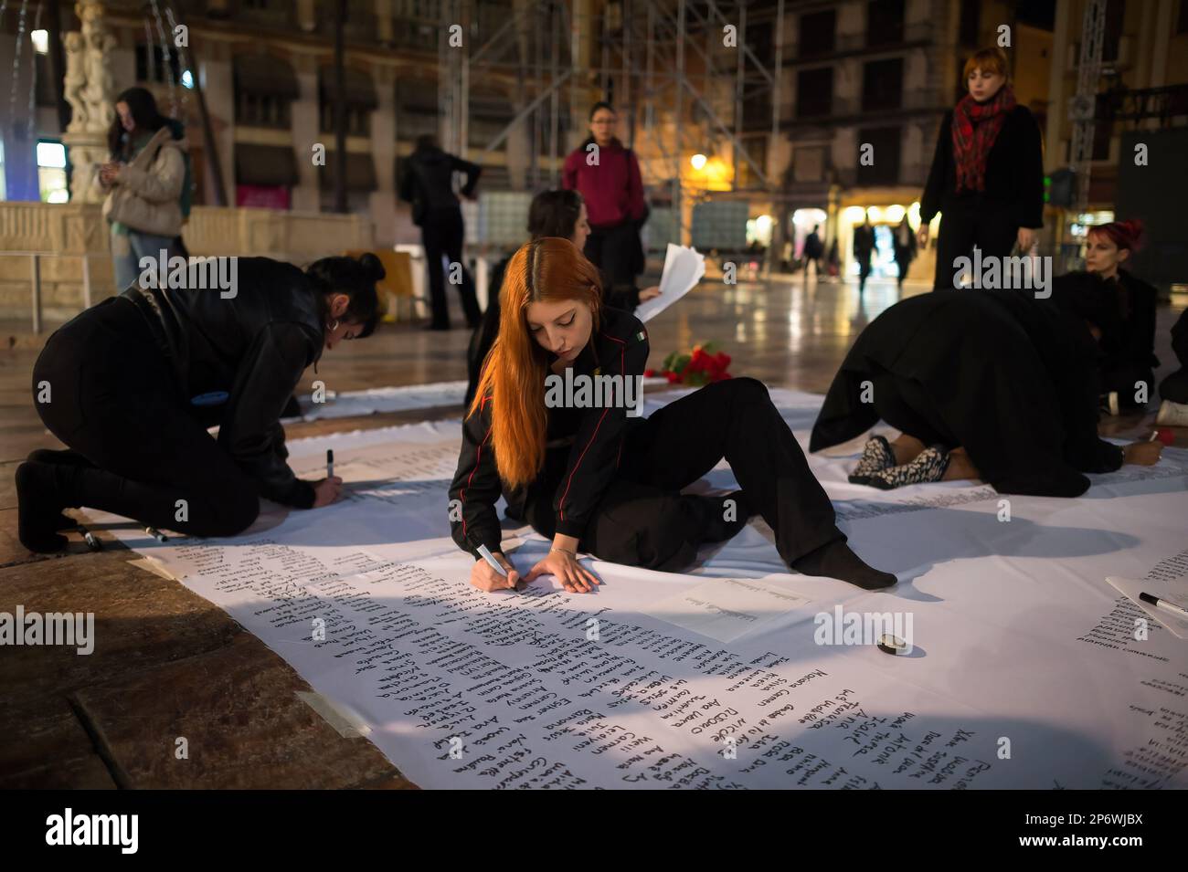 Si vedono le donne che scrivono i nomi delle donne assassinate dai loro partner in una canva prima di una rappresentazione in piazza Plaza de la Constitucion, il giorno prima della "Giornata internazionale della donna". Nell'ambito delle azioni per celebrare la Giornata internazionale della donna, decine di donne del movimento femminista autonomo di Malaga hanno partecipato a una rappresentazione simbolica per denunciare il numero di donne che sono state uccise dai loro partner nel paese. Secondo la delegazione del governo contro la violenza di genere, 1.192 donne sono state uccise dai loro partner in Spagna. (Foto di Jesus Merida/SOPA IMA Foto Stock