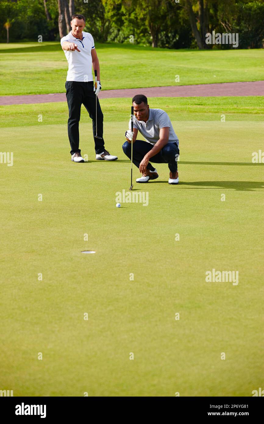 Strategia di successo. due golfers che osservano mentre la sfera si avvicina al foro. Foto Stock