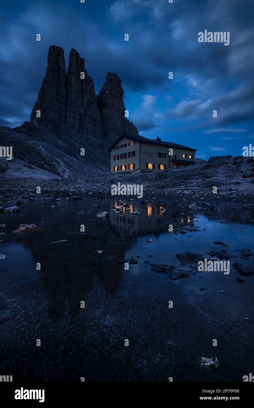 Foto del Rifugio Umberto i che riflette nel lago di notte, con la catena montuosa Torri del Vajolet sullo sfondo, Trentino, Italia Foto Stock