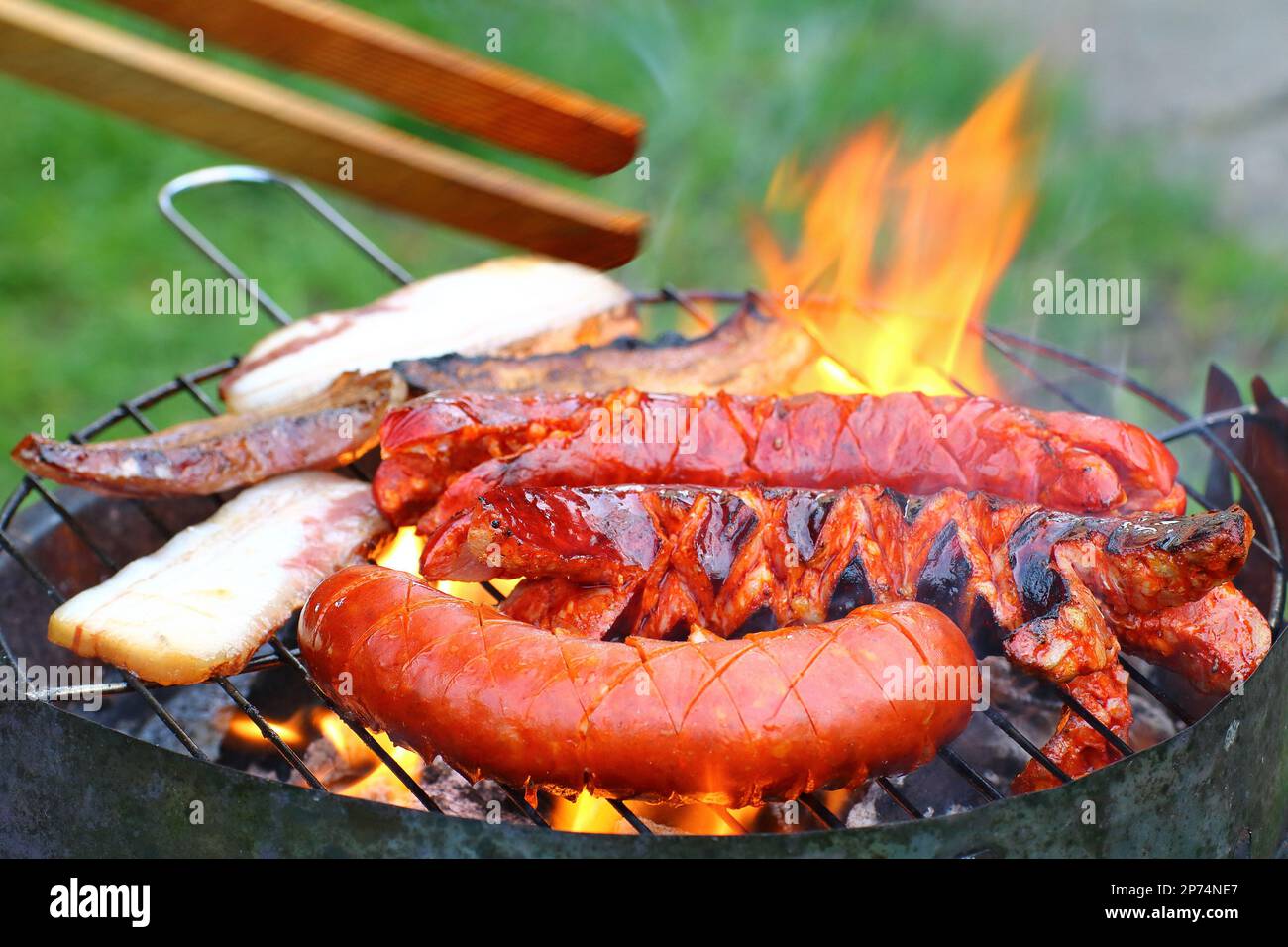 Salsicce e pancetta alla griglia Foto Stock