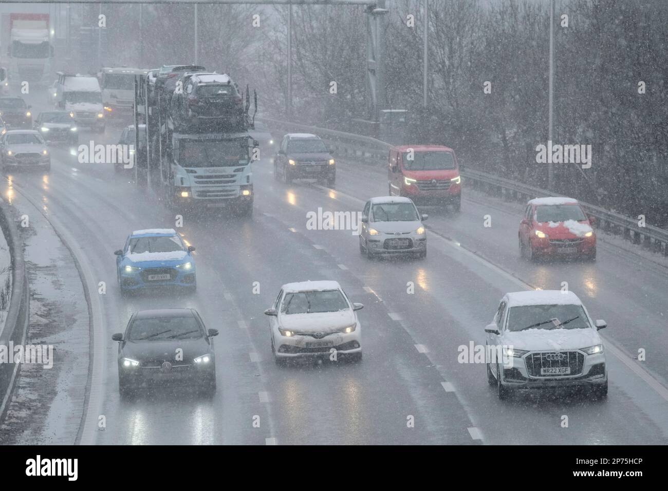 Bristol, Regno Unito. 8th Mar, 2023. Le condizioni dell'autostrada M5 a nord di Bristol tra gli incroci 16 e 17 sono scarse. La neve e lo slittino rendono difficili le condizioni durante il viaggio mattutino. Credit: JMF News/Alamy Live News Foto Stock