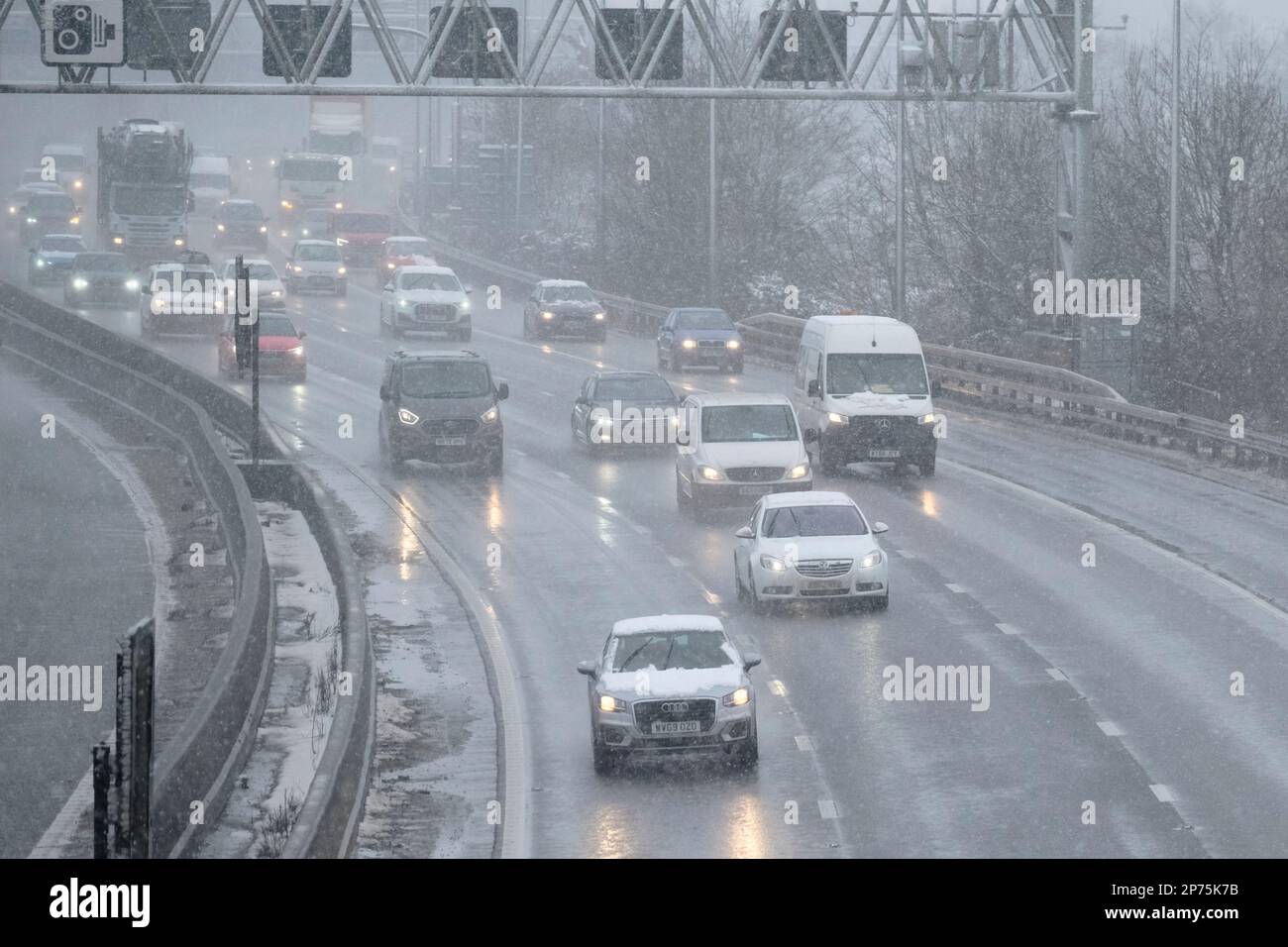Bristol, Regno Unito. 8th Mar, 2023. Le condizioni dell'autostrada M5 a nord di Bristol tra gli incroci 16 e 17 sono scarse. La neve e lo slittino rendono difficili le condizioni durante il viaggio mattutino. Credit: JMF News/Alamy Live News Foto Stock