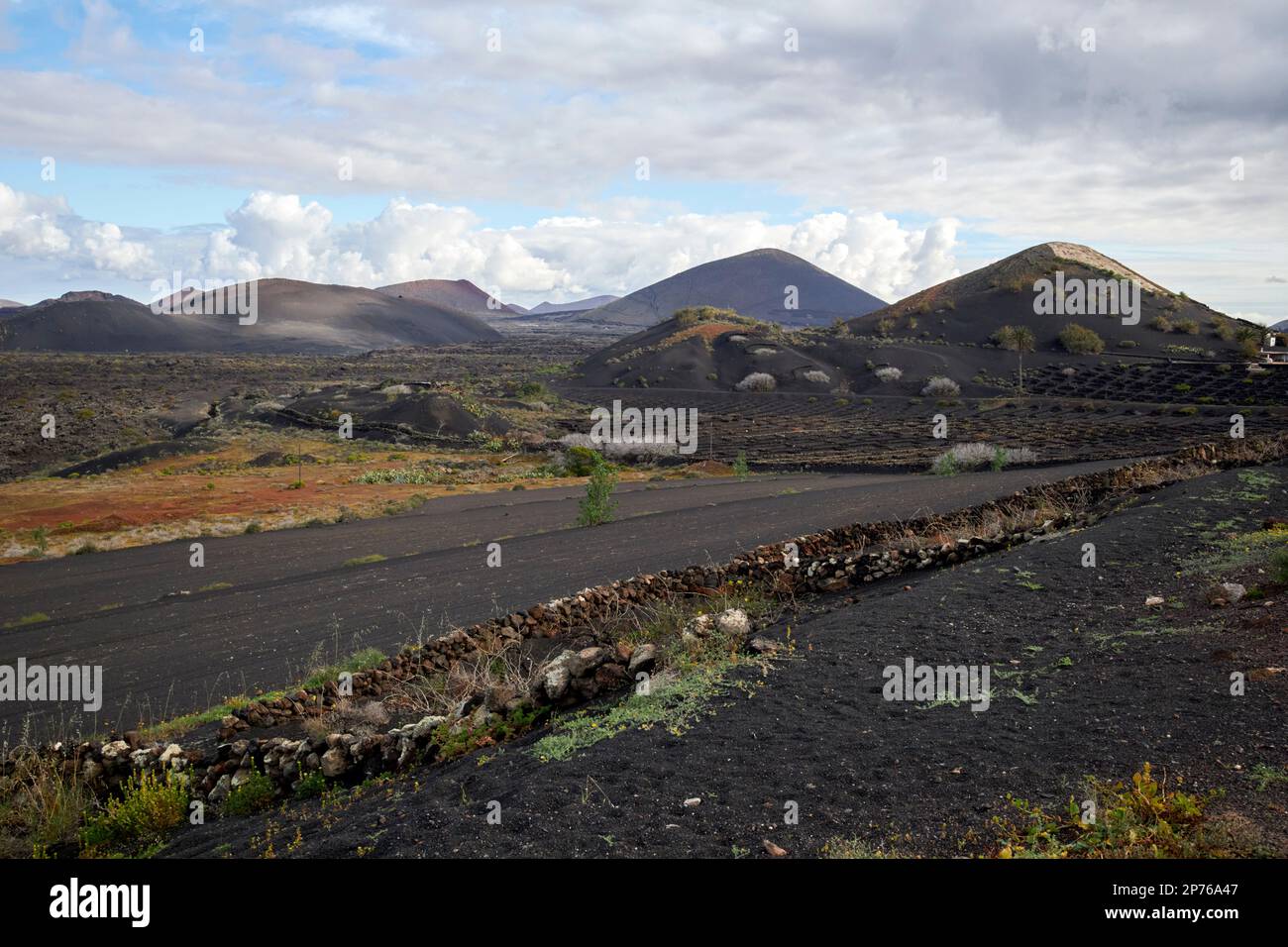 La geria regione vinicola paesaggio con vulcani sullo sfondo Lanzarote, Isole Canarie, Spagna Foto Stock