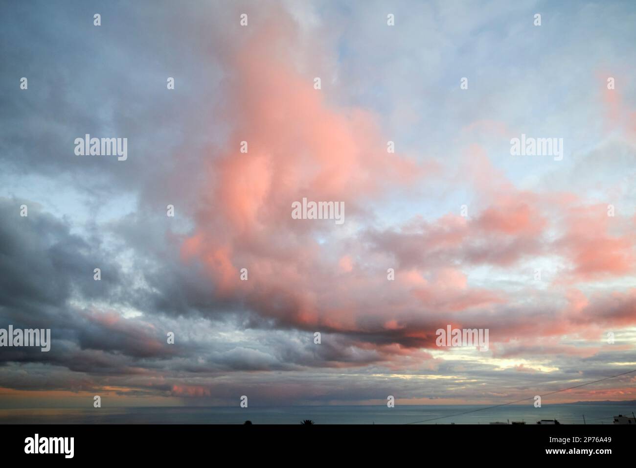 Cielo nuvoloso rosa e rosso incandescente a causa del sole tramontare sul mare Lanzarote, Isole Canarie, Spagna Foto Stock