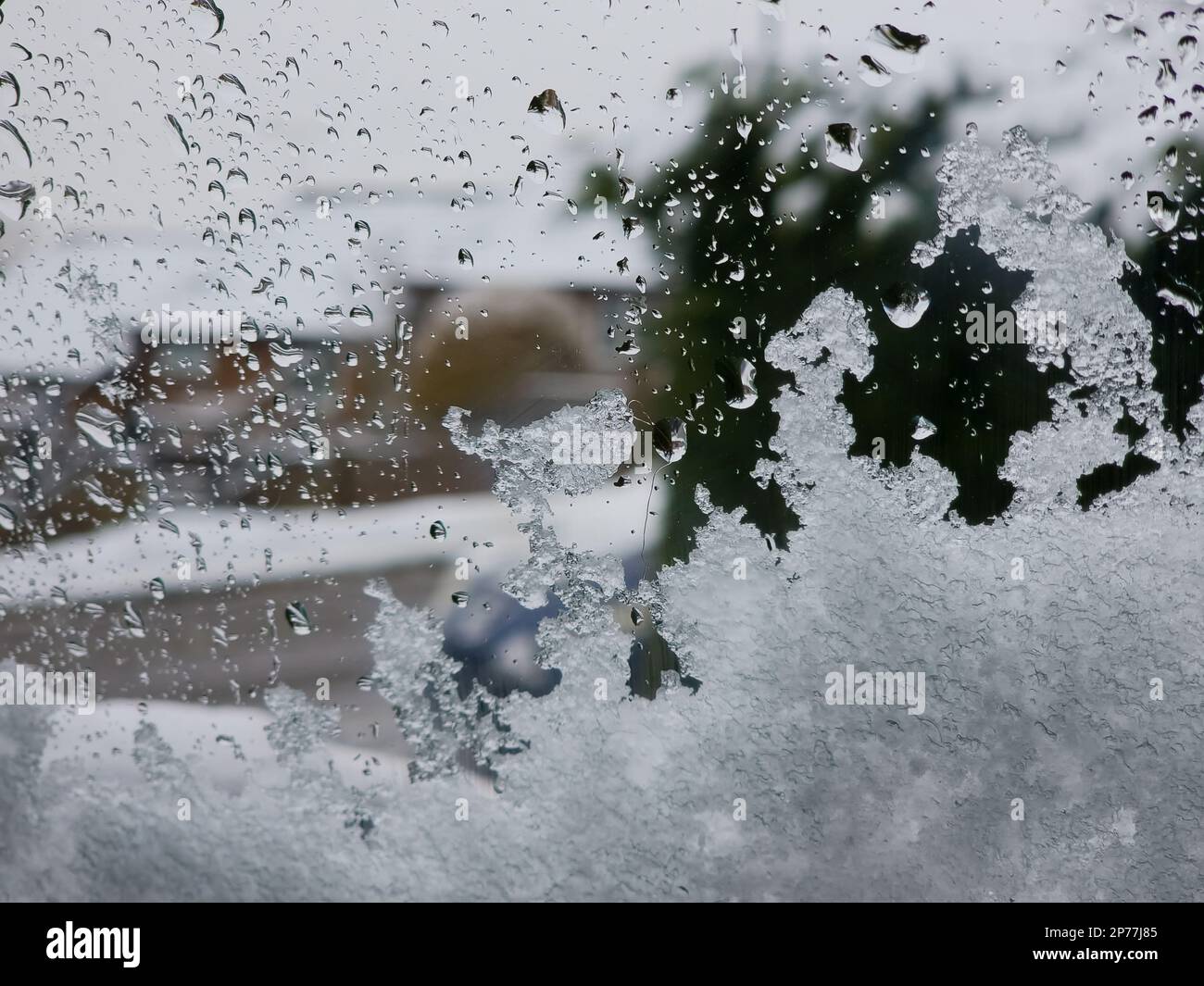 Neve e acqua su una finestra che si affaccia. Foto Stock