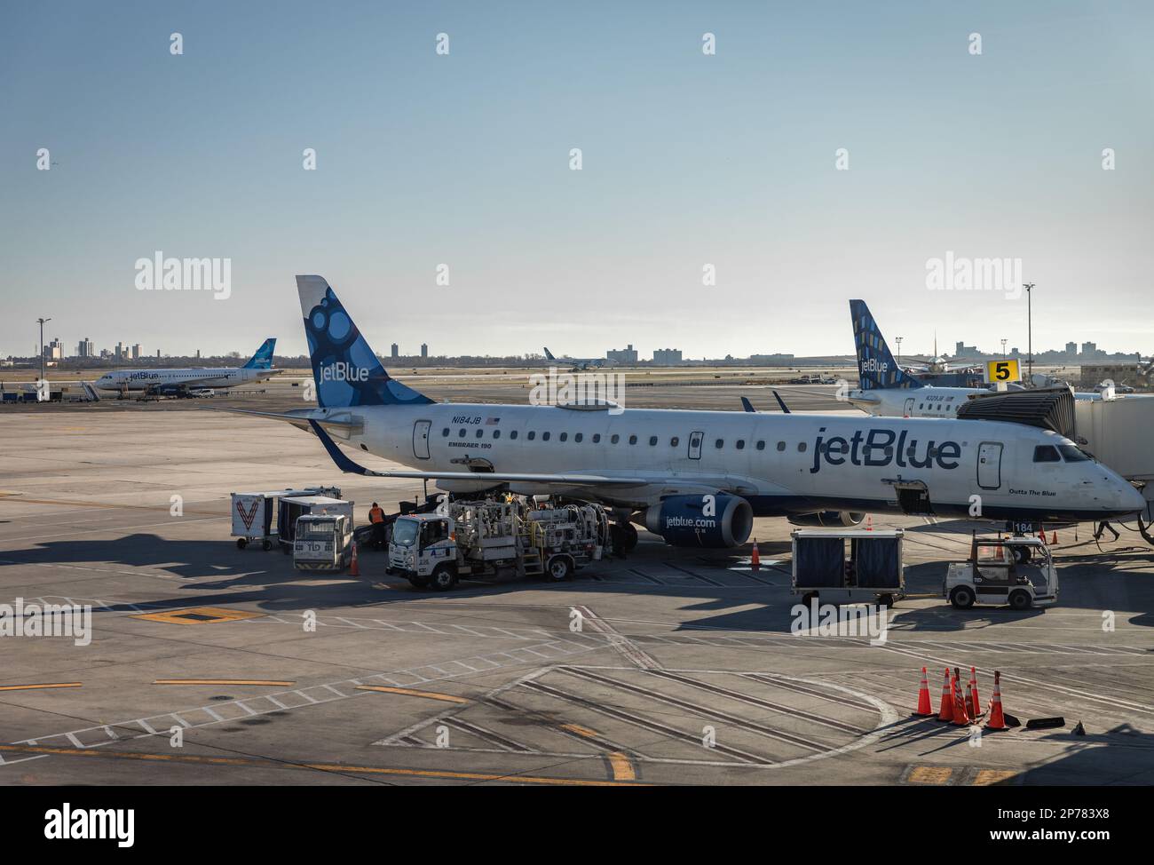 Un aereo commerciale JetBlue sulla pista di un aeroporto, il suo naso punta verso una rampa di carico Foto Stock