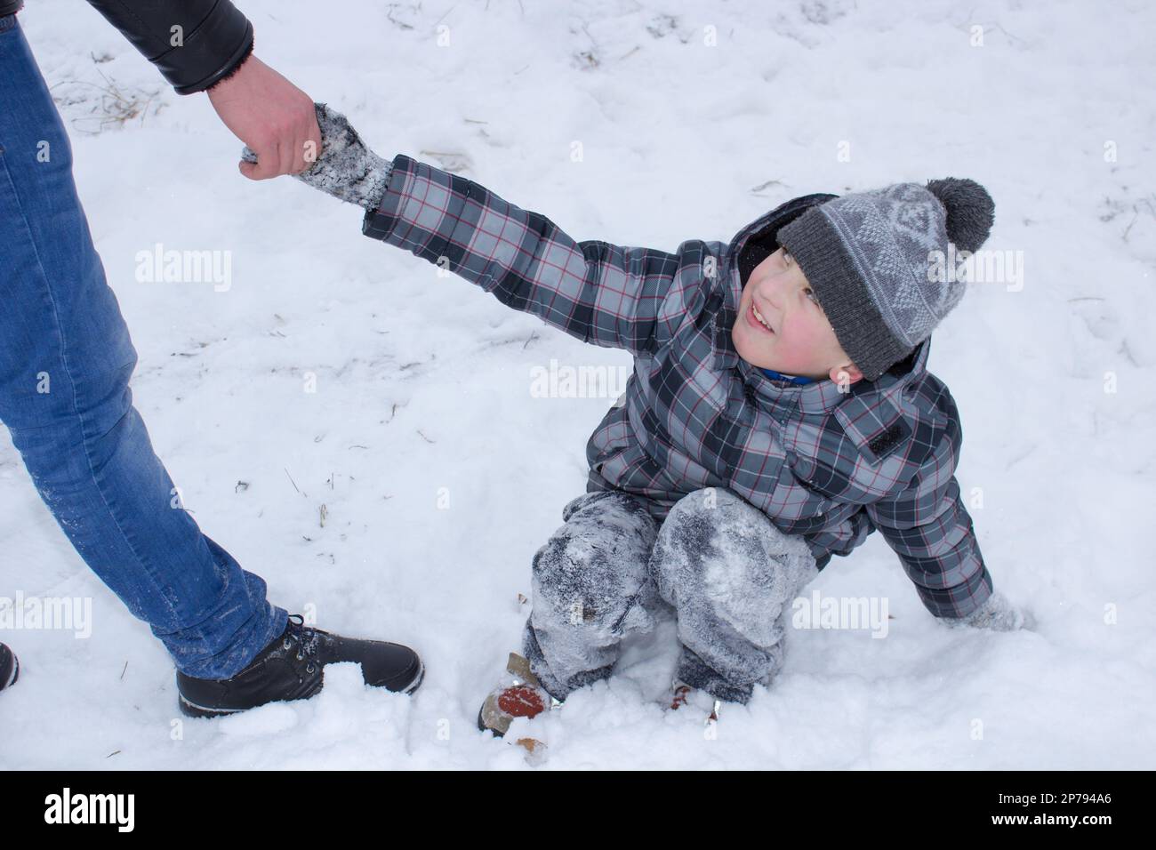 Il ragazzo aiuta a alzarsi dalla neve Foto Stock