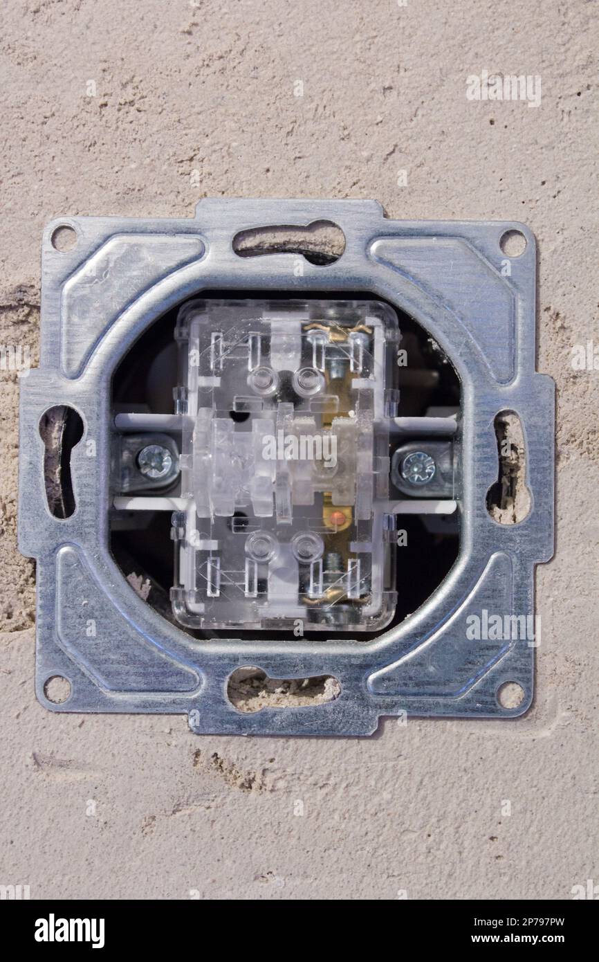 Aprire la presa elettrica senza pannello anteriore. Operazioni sull'installazione della presa a muro. Foto Stock