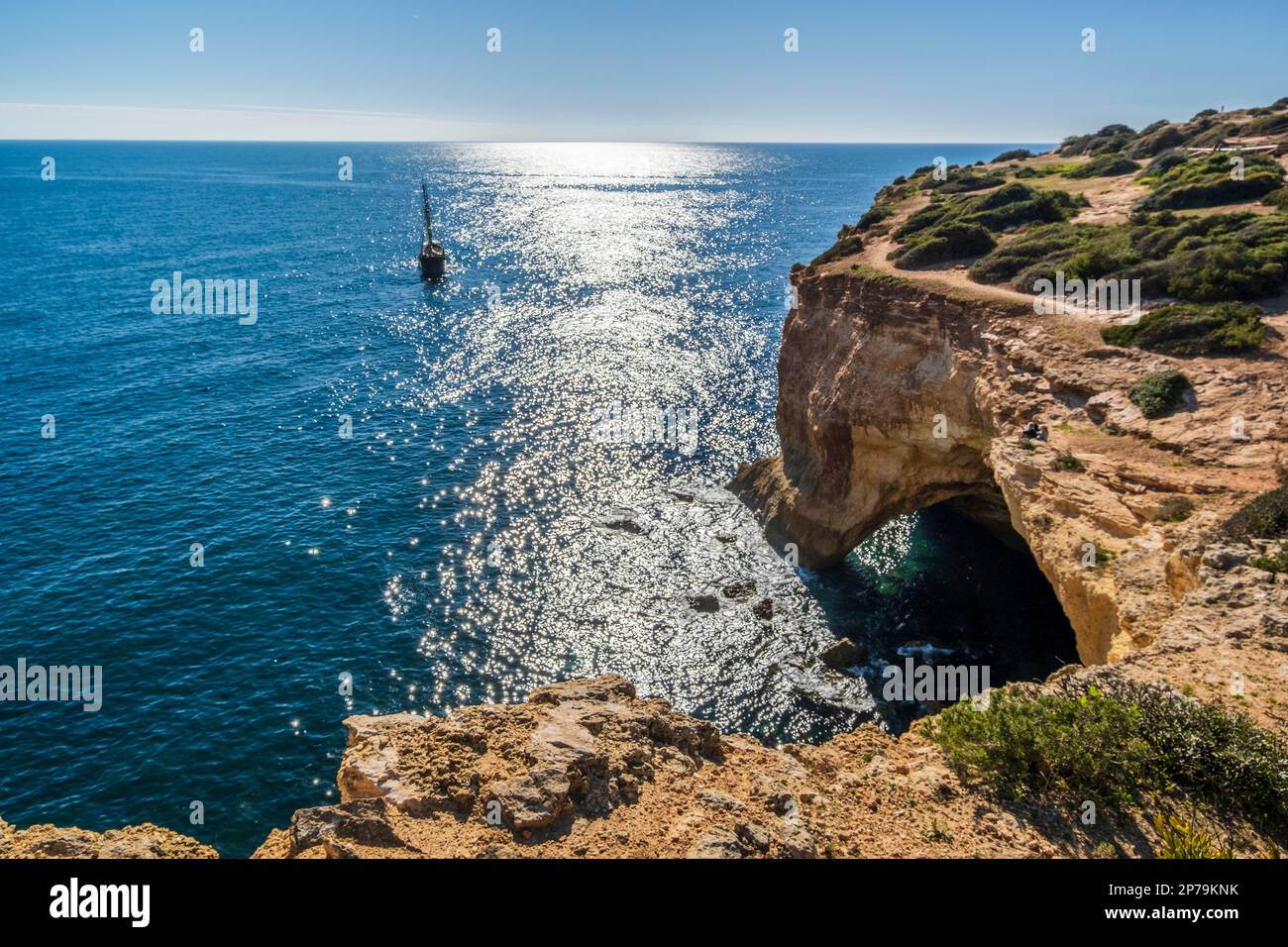 Barca a vela sull'Oceano Atlantide, scogliere e arco sulla costa dell'Algarve, a sud del Portogallo Foto Stock