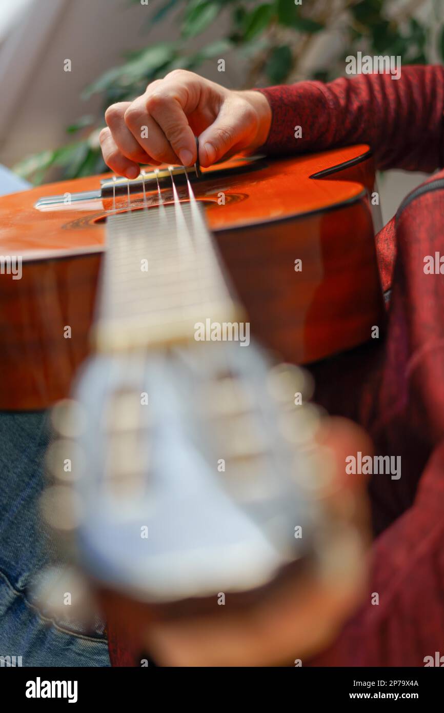 Primo piano di una mano mans che gioca la chitarra spagnola selettiva focus Foto Stock
