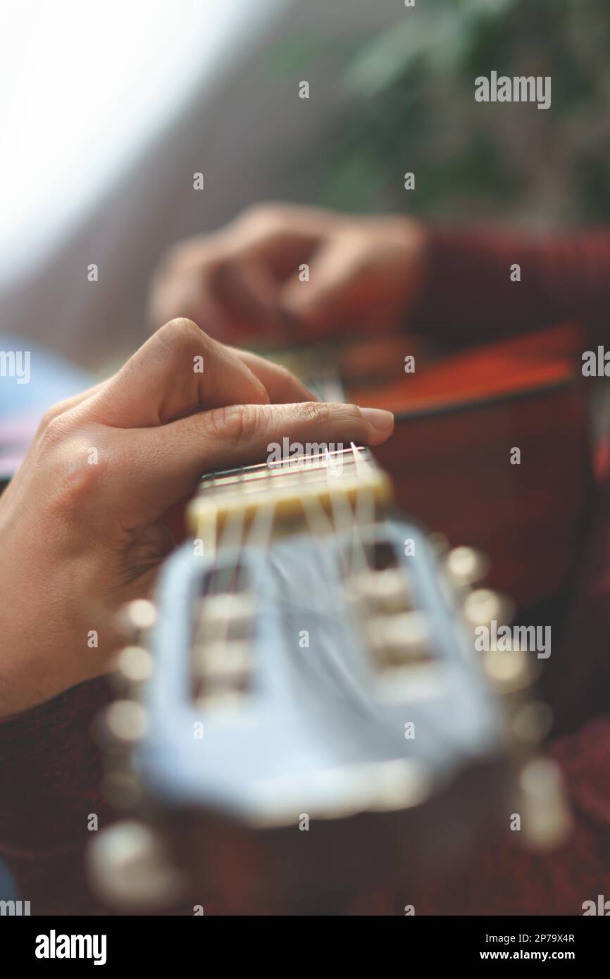 Primo piano di una mano mans che gioca la chitarra spagnola selettiva focus Foto Stock