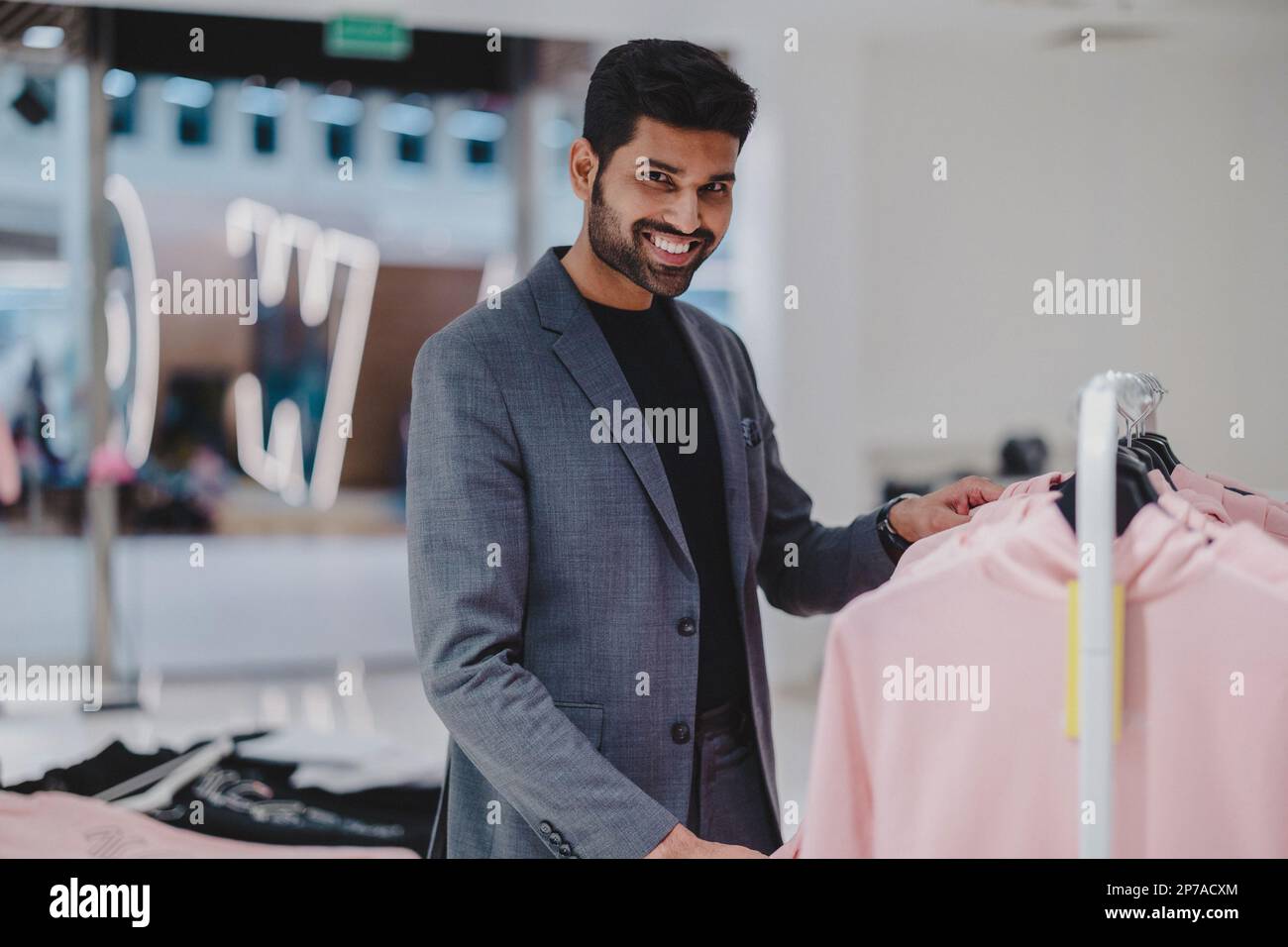 Giovane uomo che lavora in un negozio di abbigliamento Foto Stock