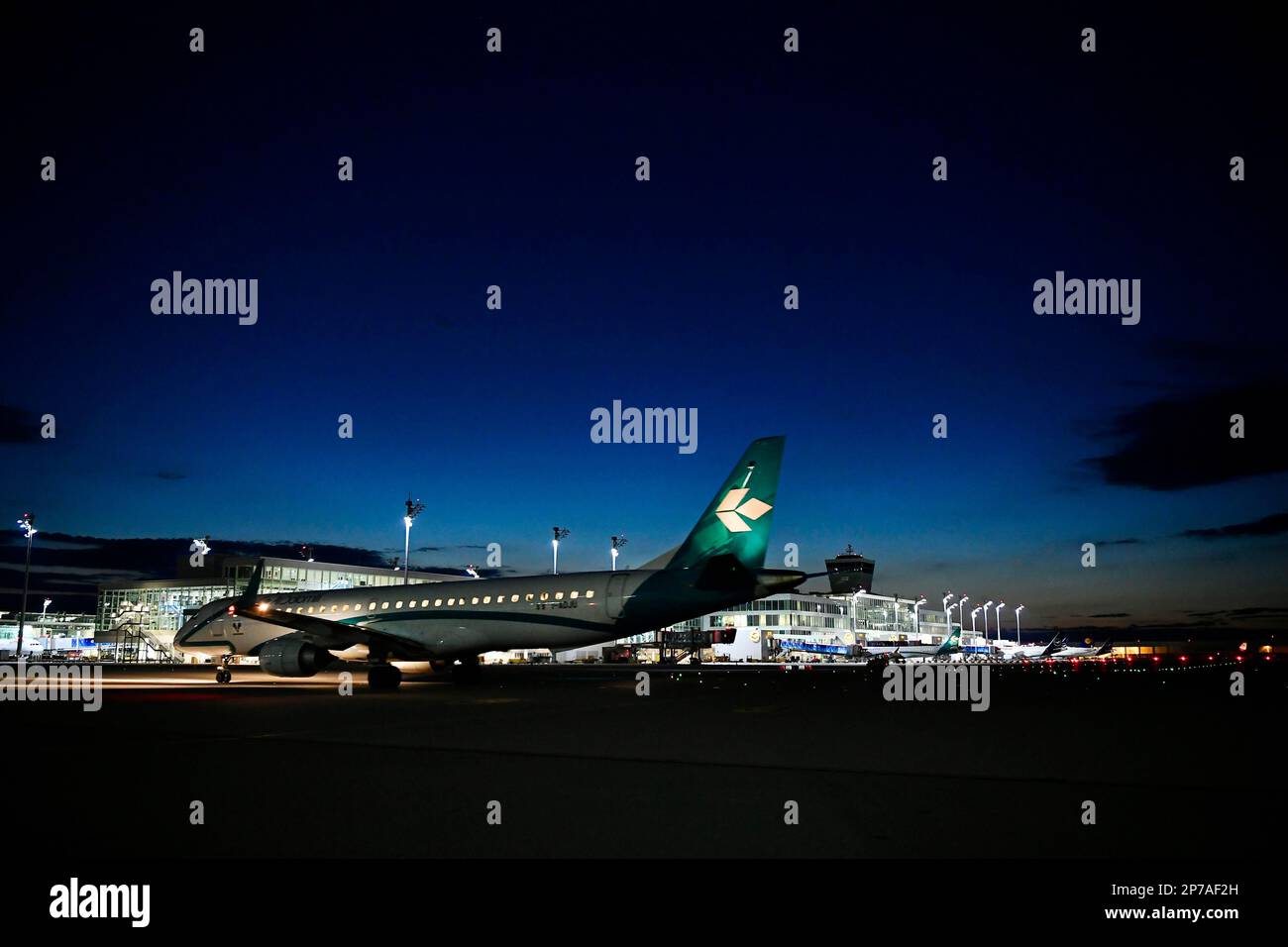 Air Dolomiti Embraer ERJ-195LR (ERJ-190-200 LR) tassando di notte davanti al terminal satellite 2, aeroporto di Monaco, alta Baviera, Baviera, Germania Foto Stock