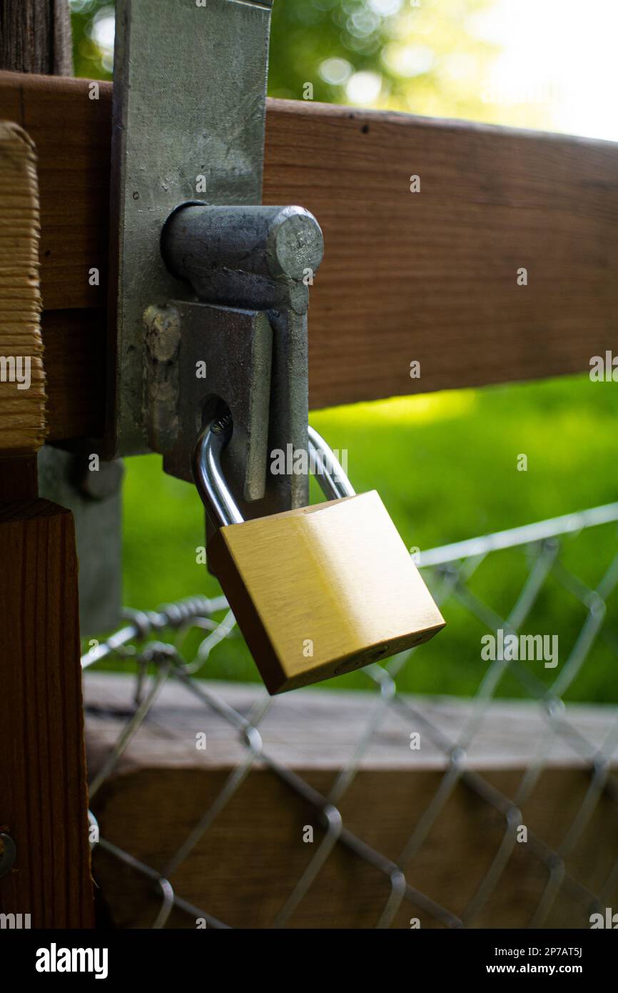 Blocco in metallo solido su un cancello di recinzione con maglia a catena. Foto ravvicinata all'aperto, estate, giorno, luce del sole, non c'è gente. Foto Stock