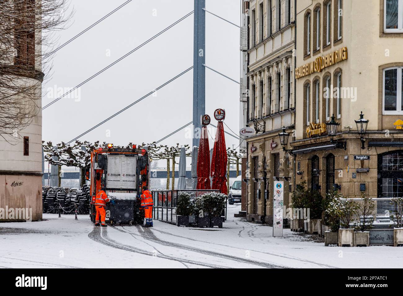 Dusseldorf in tempo nevoso e fangoso, raccolta di rifiuti nel centro storico di Burgplatz Foto Stock