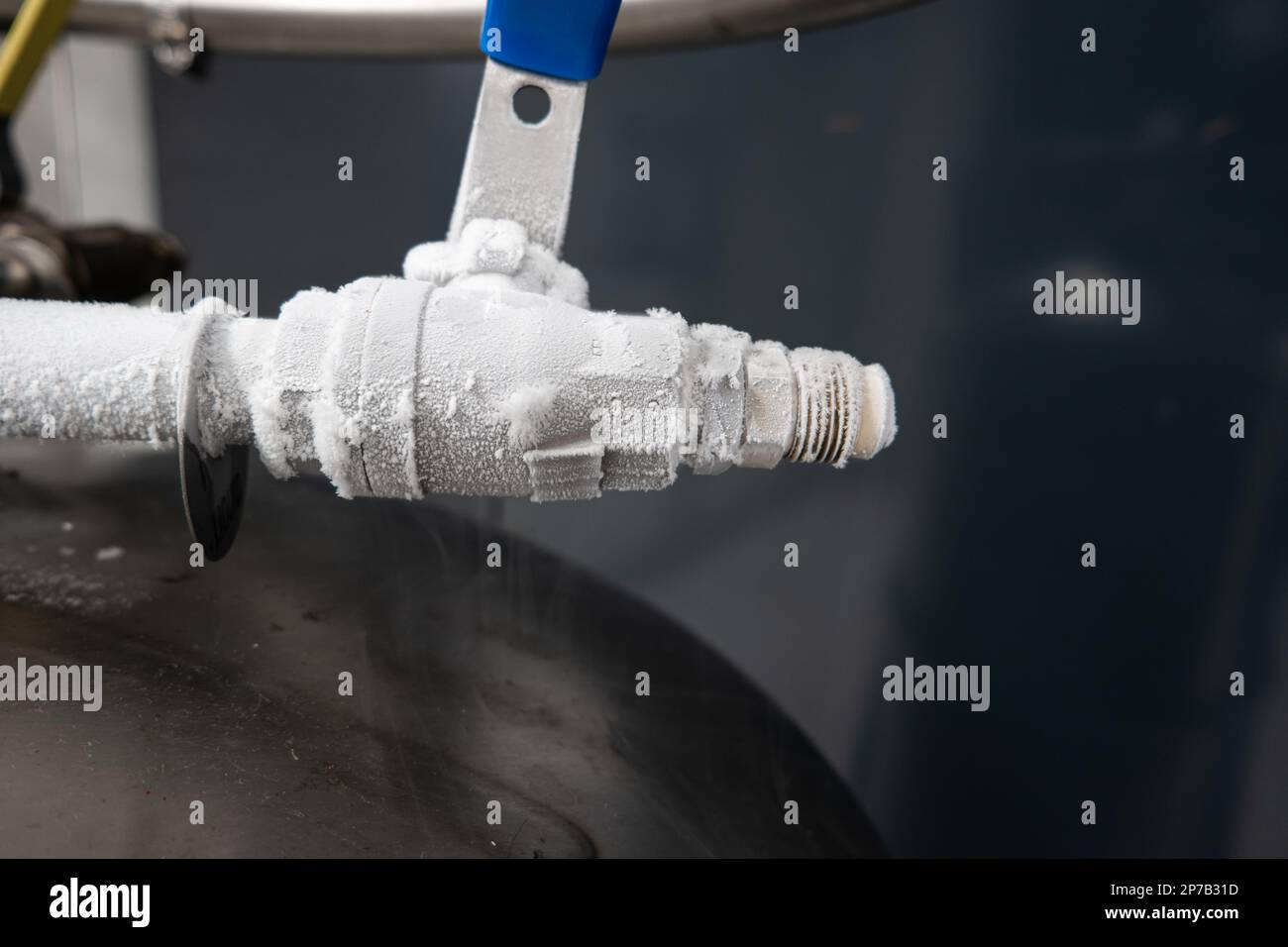Azoto liquido congelato valvola di trasferimento serbatoio scollegata, shot ravvicinati, nessuna persona. Coperto da piccoli cristalli di ghiaccio. Foto Stock