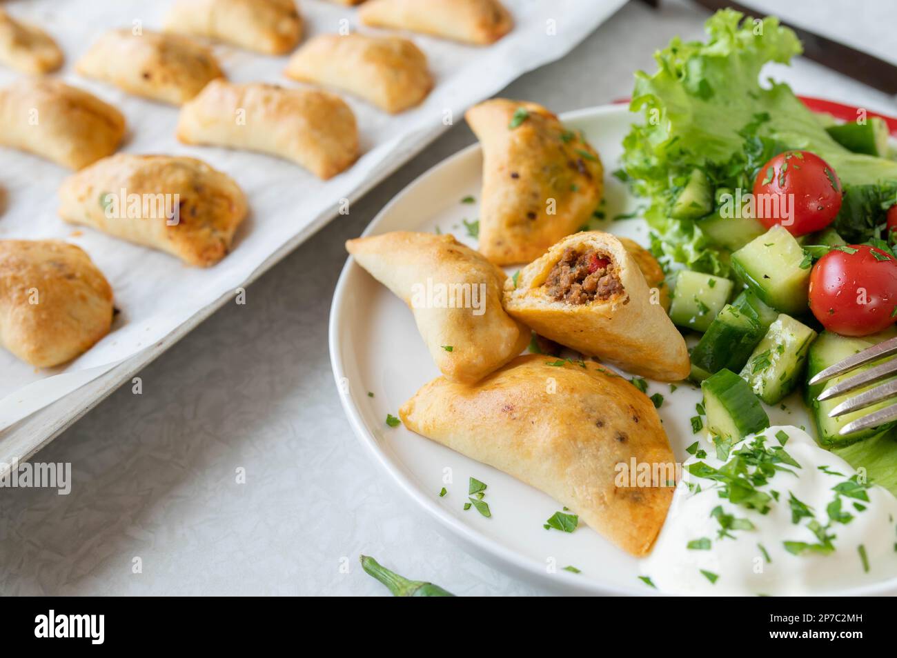 Empanadas con macinato di manzo, ripieno di formaggio e insalata di contorno Foto Stock