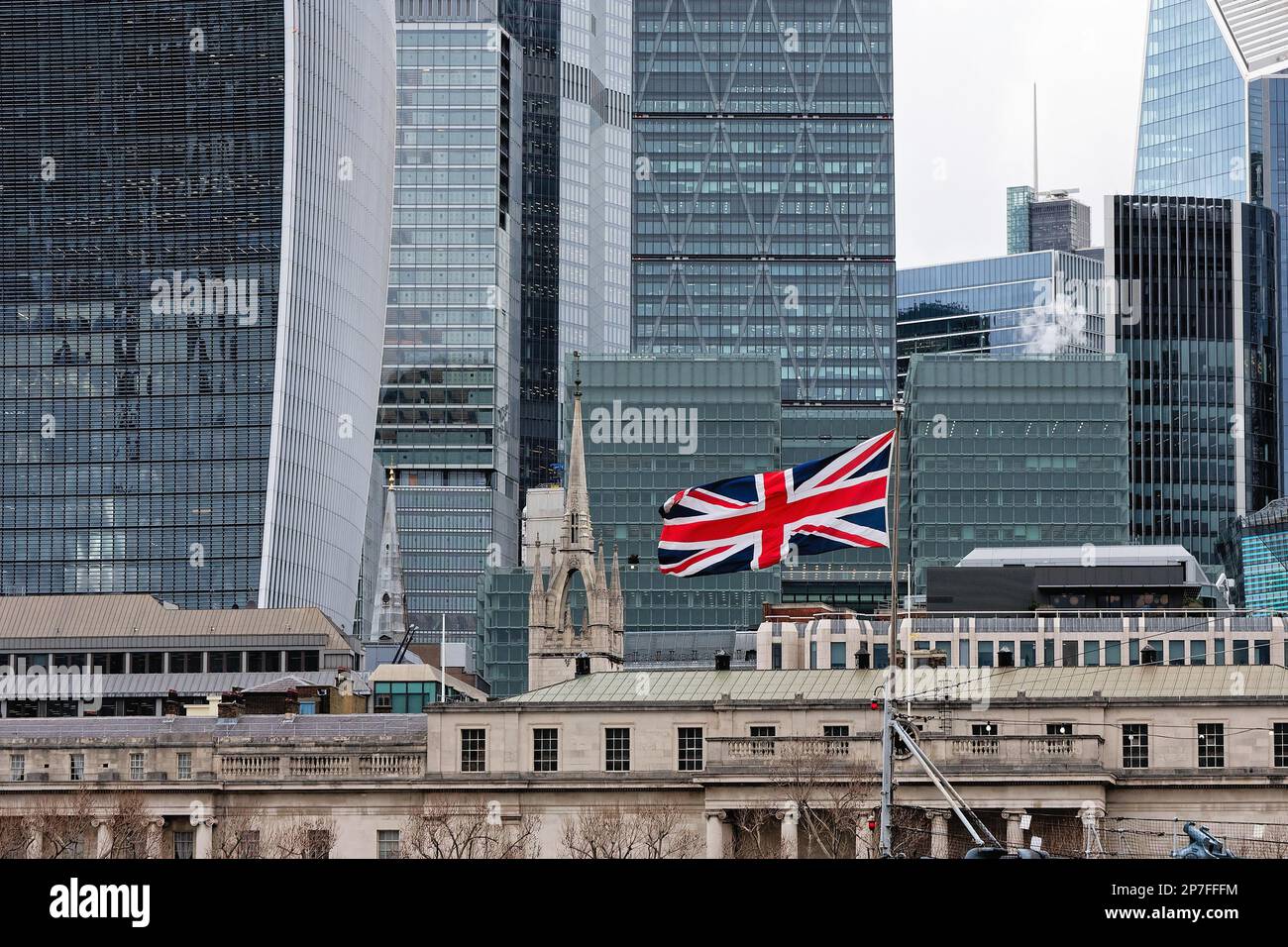 Una singola bandiera di Union Jack che vola sullo sfondo della città di Londra, i grattacieli architettonici moderni, Londra Inghilterra UK Foto Stock