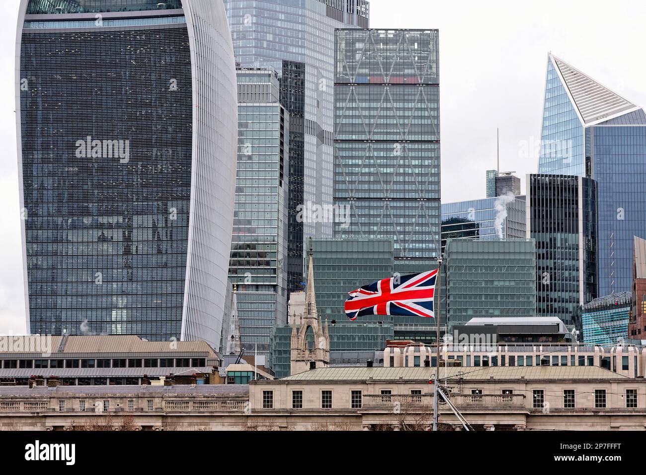 Una singola bandiera di Union Jack che vola sullo sfondo della città di Londra, i grattacieli architettonici moderni, Londra Inghilterra UK Foto Stock
