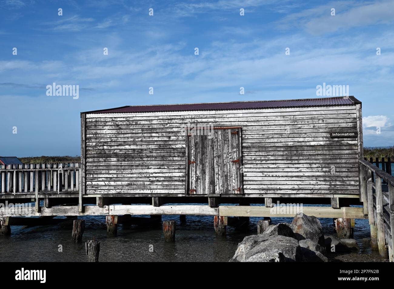 Il pontile, il molo e la casa barca presso la costa occidentale insediamento di Okarito. Durante la corsa all'oro del 1860s, Okarito vide sbarcare più di 500 minatori in un giorno. Foto Stock
