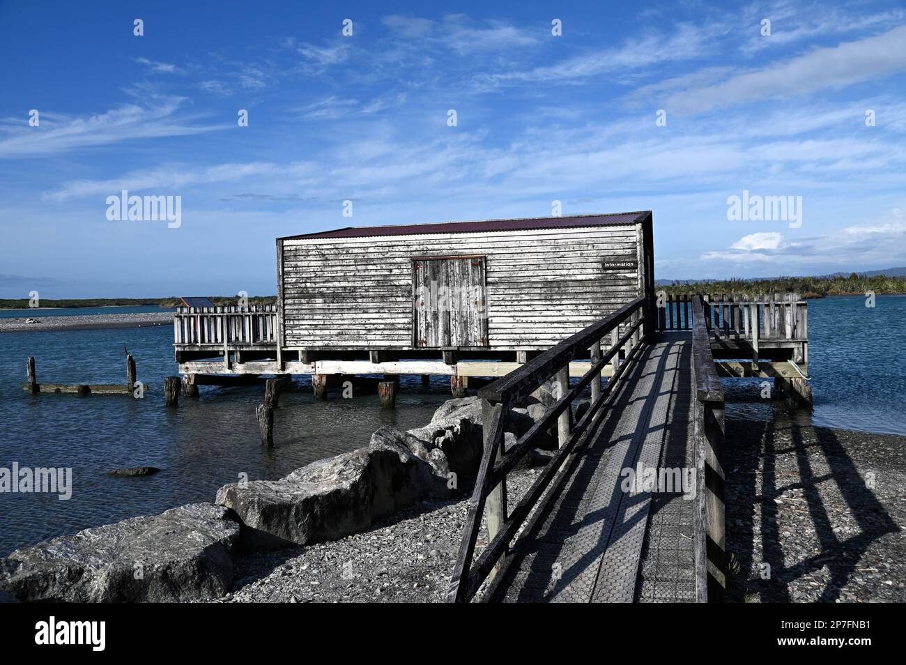 Il pontile, il molo e la casa barca presso la costa occidentale insediamento di Okarito. Durante la corsa all'oro del 1860s, Okarito vide sbarcare più di 500 minatori in un giorno. Foto Stock
