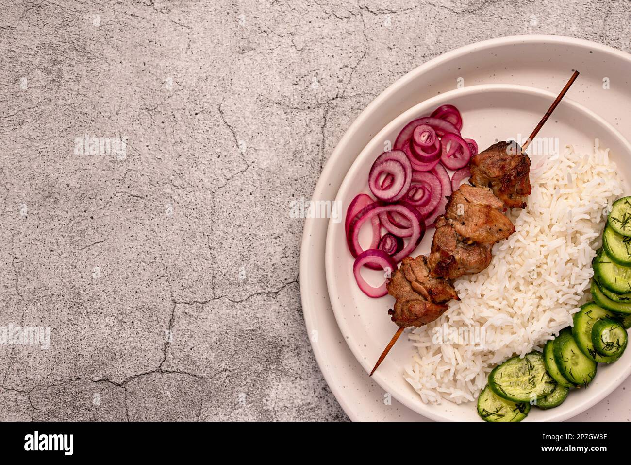 Fotografia di cibo bianco di carne alla griglia, kebab, barbecue, arrosto, maiale, agnello, marinata, cipolla, riso, insalata, cetriolo Foto Stock