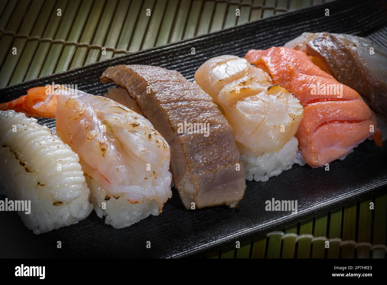 Sushi temaki di stile giapponese con gamberi, tonno, polpo, calamari su piatto nero, cibo asiatico, cibo tradizionale giapponese Foto Stock