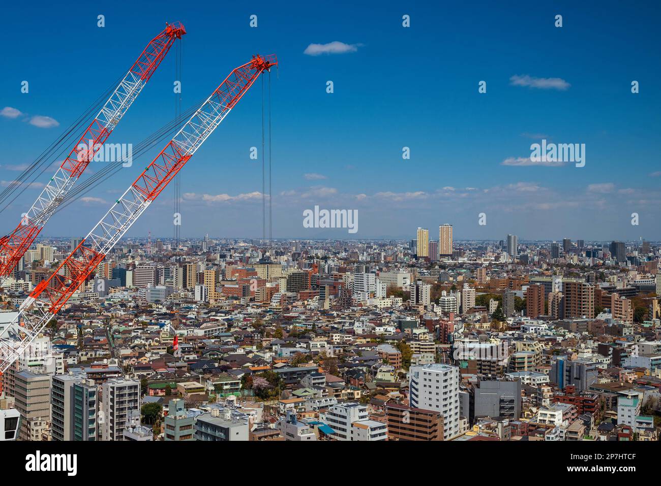 Edilizia e sviluppo. Gru al lavoro tra i sobborghi infiniti di Tokyo Foto Stock