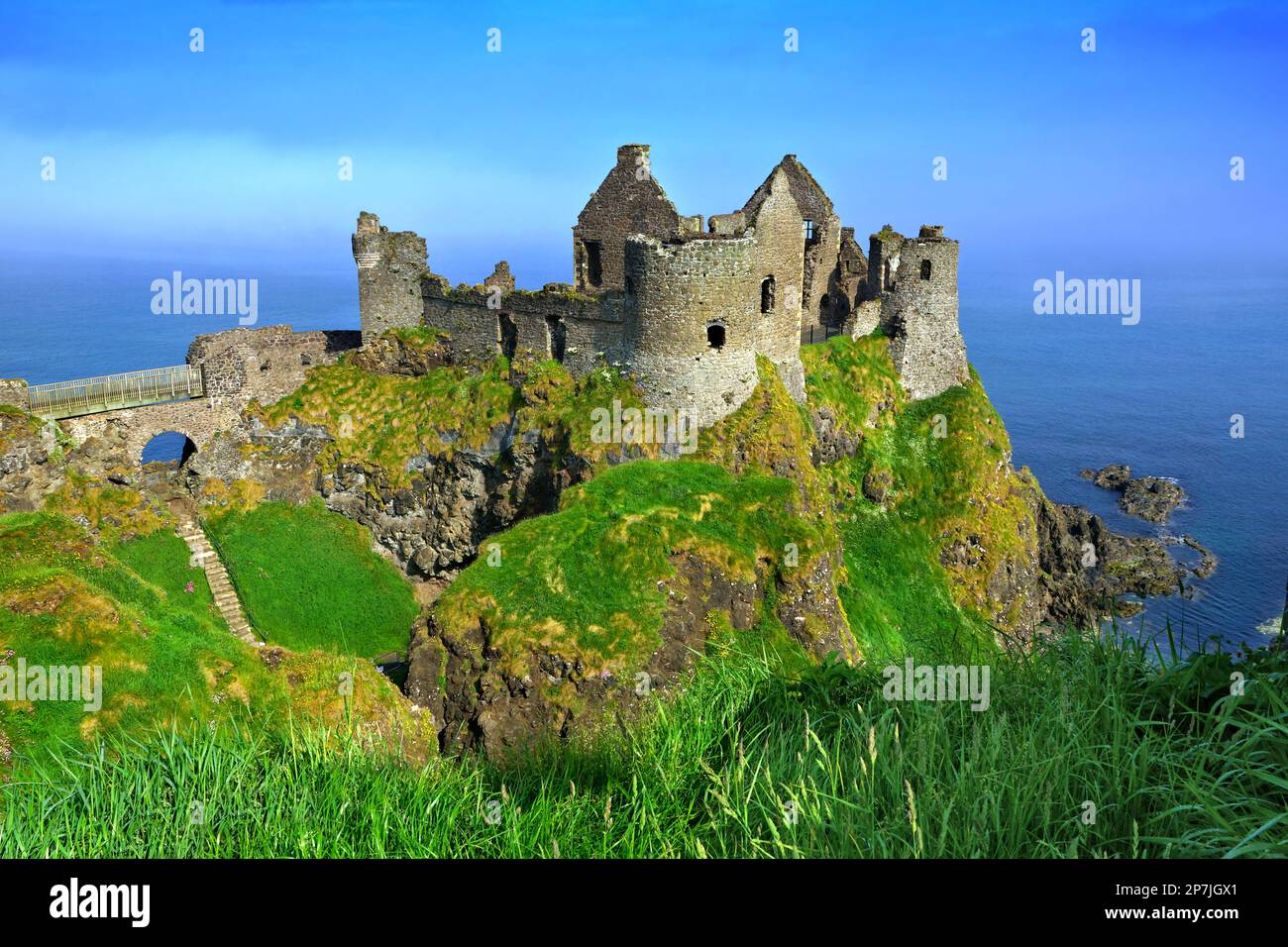 Rovine del castello medievale di Dunluce che si affaccia sulle scogliere panoramiche della Causeway Coast, Irlanda del Nord Foto Stock