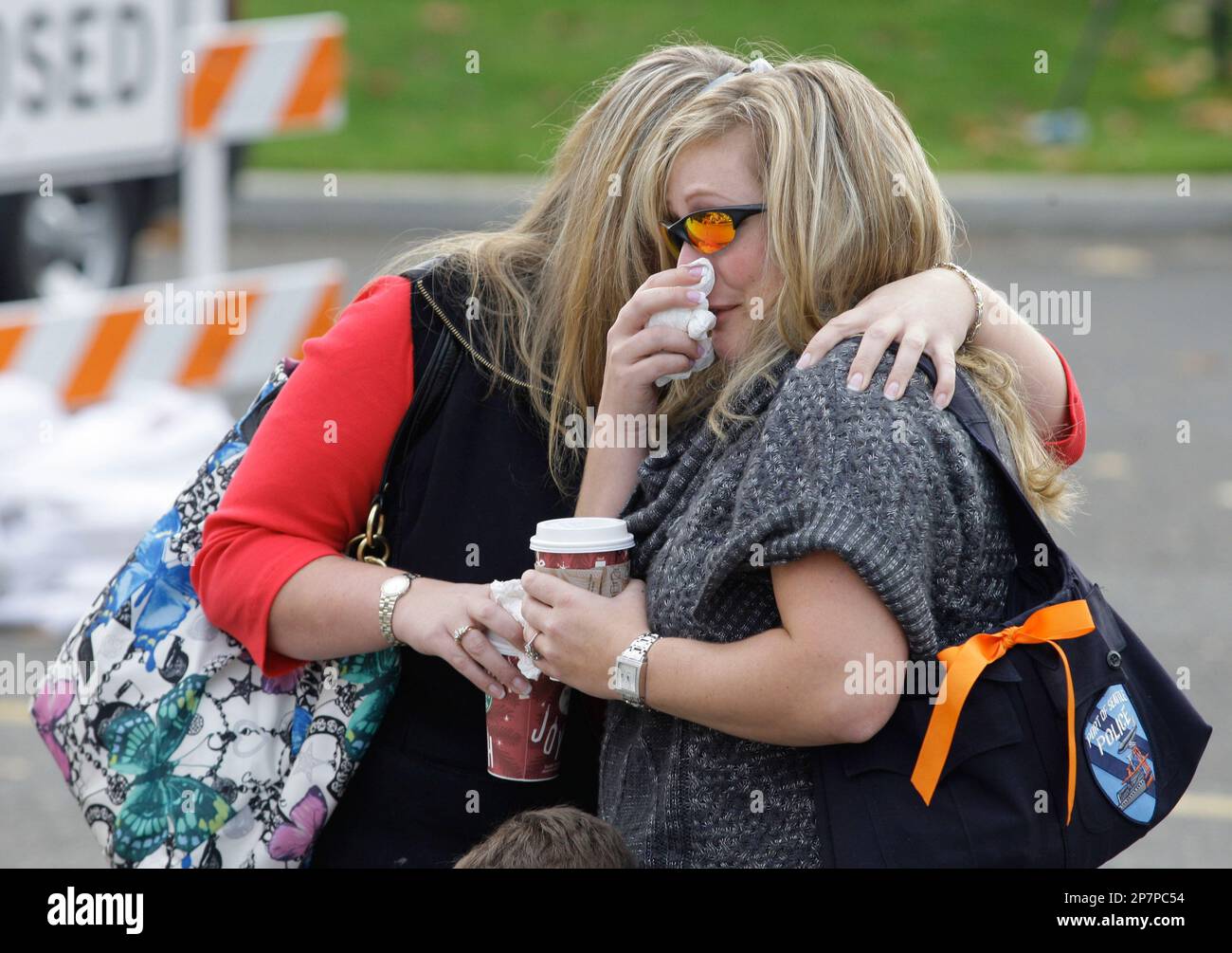 Two women, who declined to give their names, comfort each other, Monday, Nov. 30, 2009, as they visit a memorial at the Lakewood Police headquarters in Lakewood, Wash. Four Lakewood Police officers were fatally shot Sunday morning as they sat in a coffee shop in Parkland, Wash. (AP Photo/Ted S. Warren) Foto Stock