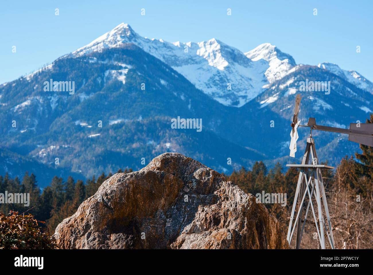 Banderuola da grande roccia con idilliaca montagna coperta di neve in Foto Stock