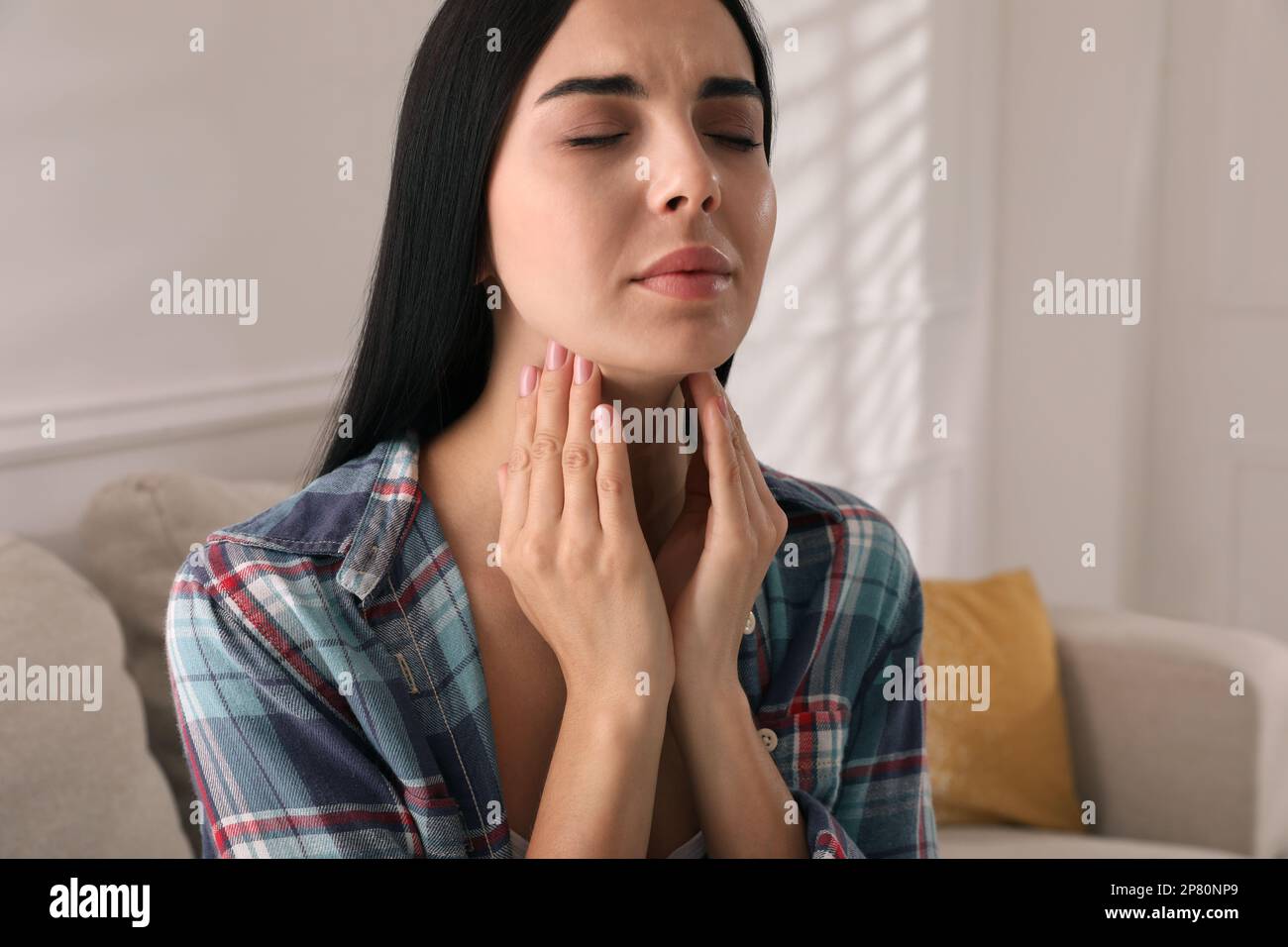 Giovane donna che fa l'esame di auto della tiroide nel paese Foto Stock