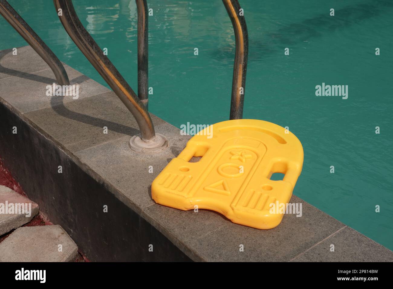 Nuoto in plastica kick board galleggiante nella rinfrescante piscina blu Foto Stock